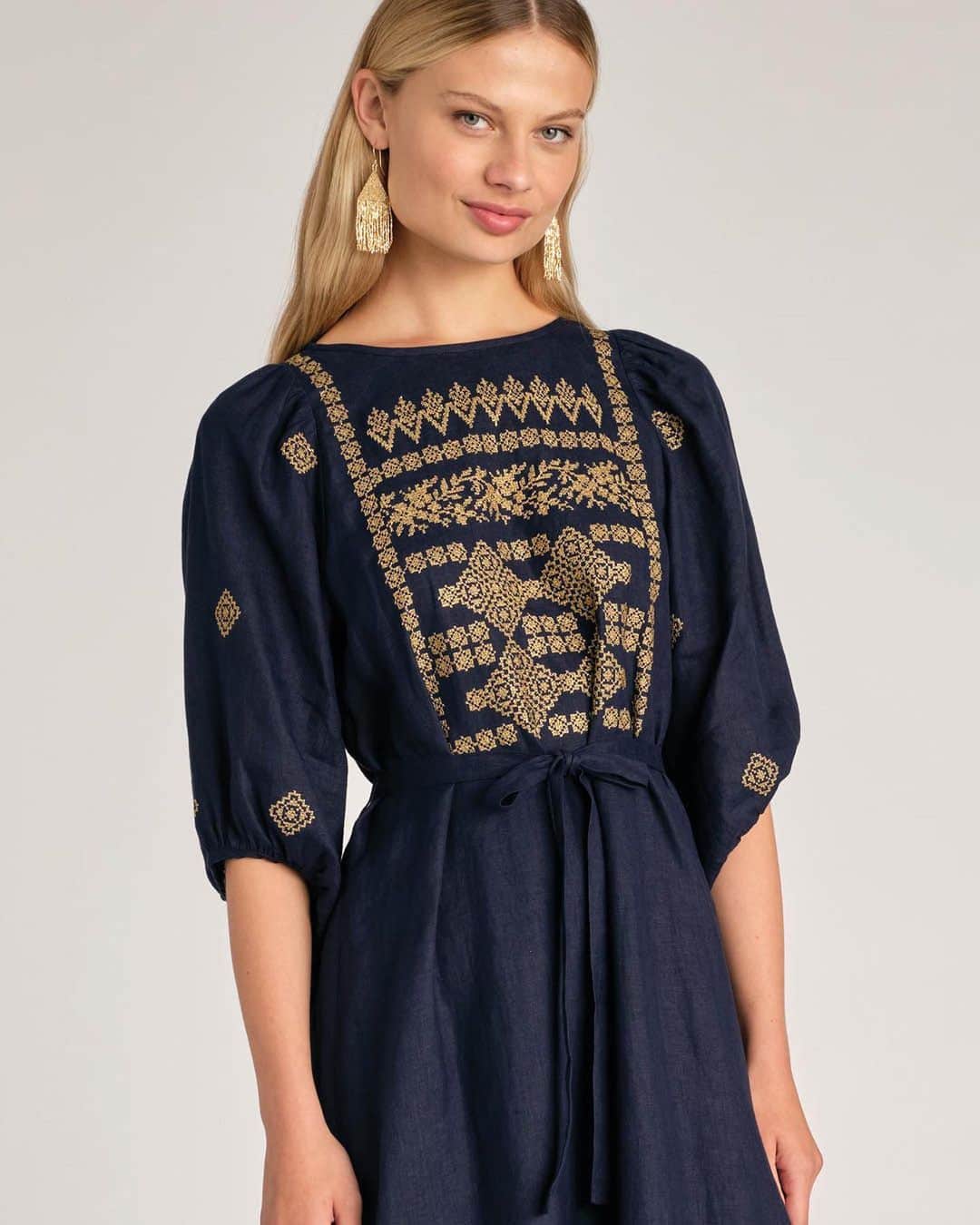 ミーガンパークのインスタグラム：「INTRODUCING The Freya Polished Linen Dress.  Golden metallic zari thread creates the intricate folkloric embroidery that is the feature of this design.  Upon a polished lightweight linen, the glistening embroidery elevates this silhouette to create a design that is perfect for a special occasion.  Tailored to skim the body, the waist which is defined by a narrow fabric belt and gathered balloon sleeves create a chic silhouette where it is the embroidery that is celebrated as the hero of this modern yet timeless piece.」