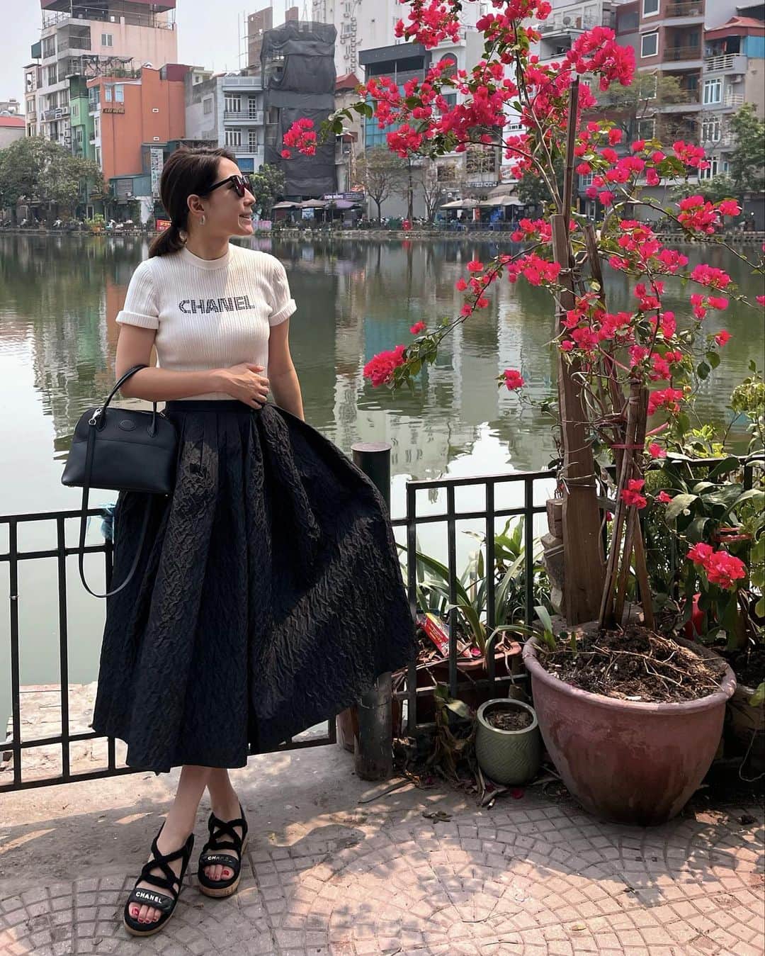 髙田麻紀子のインスタグラム：「❤︎ . 打ち合わせまで、バイクタクシーで🛵(2枚目) . 私がバイクに乗るのなんて意外！とか、キャラ変が凄い！とか、お友達からはウケる！なんてDMを結構いただくのですが、拘るところは拘るけど、わりと柔軟に何処でも生きていけるタイプみたいです😂  こんな経験も期間限定だと思うと貴重なものなはず❣️  ちなみにバイクに乗っている時の気分だけは、ローマの休日です🛵😂  トップス＆サンダル#CHANEL スカート#cygne バッグ#HERMES  #ハノイライフ　#hanoilife」