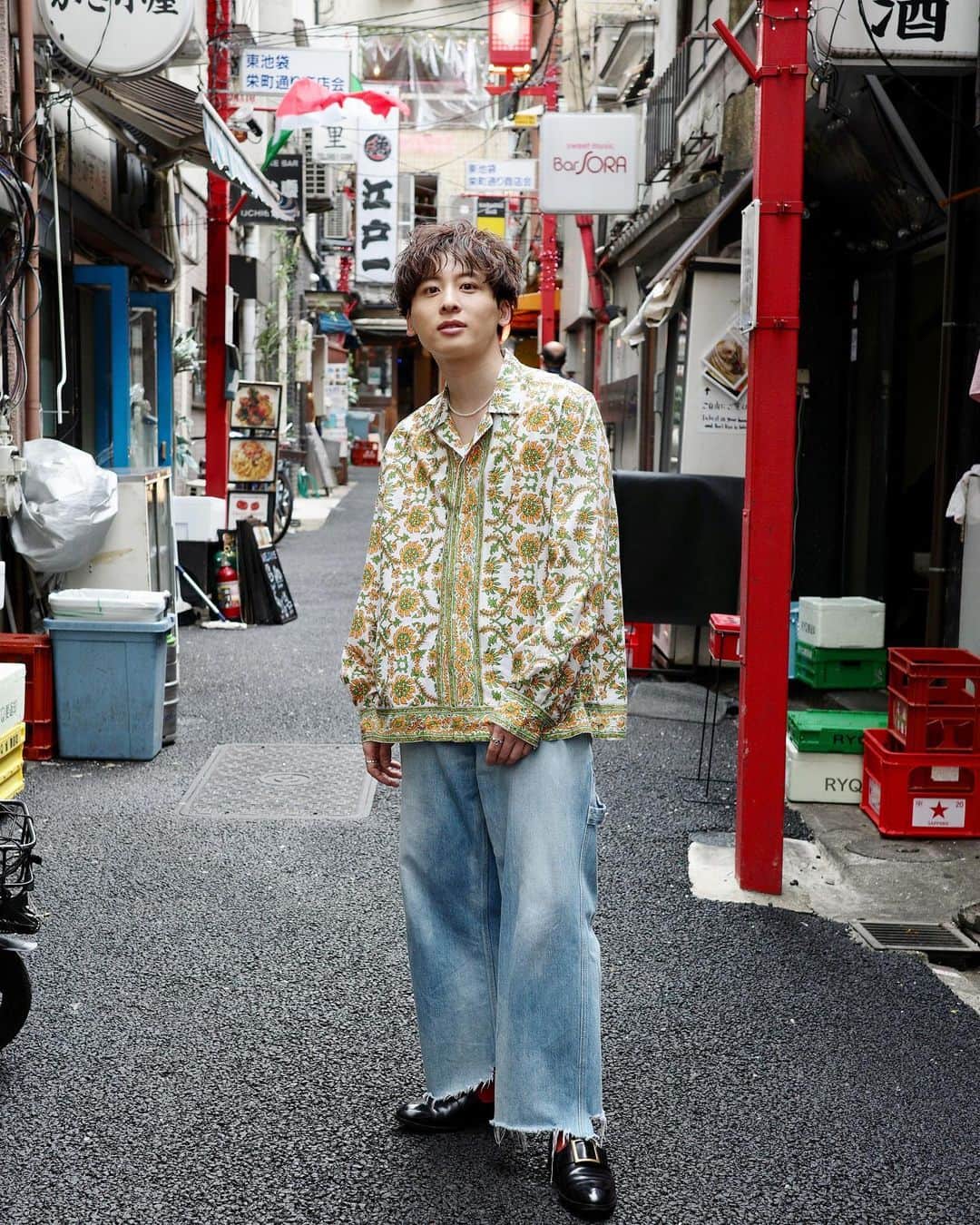 工藤大輝のインスタグラム：「私服。  池袋の裏路地で撮ったら純悪さんっぽくなった。 柄シャツ×裏路地の掛け算を侮ってました。  と言うことで、@bode のシャツ。 BODEは良い柄とサイズがあると手にとっちゃう。 これは去年のかな。FFのモルボルみたいな柄🌼 昔だったら柄モノは避けてたんだけど、今はむしろ好物に。  ちなみにBODEはサイズも物によってマチマチなので着てみないと分からないですが、大体XL/XXLっていう1番でかいサイズを狙ってます。あんまり無い。  @claquepot_official のツーマン衣装に貸し出し済み。  ネックレスは @celine の4,5年くらい前のやつだった気がします。パールがまだそんなにリバイバルしてない時にしれっと出てたやつ。粒の小ささと長さが丁度良くてながーく使ってます。  デニムは前も載せた @class_poolbyclass の。 なんやかんやヘビロテ。  靴は @calmanthology で @tomorrowland_jp の別注。これももう３年前になるかもですね。どデカいバックルがアクセントになるドレスローファー。スポッと履けるのも良いところ。足がむくむと痛くて歩けなくなる所もポイントです。  #bode #celine #poolbyclass #calmanthology」