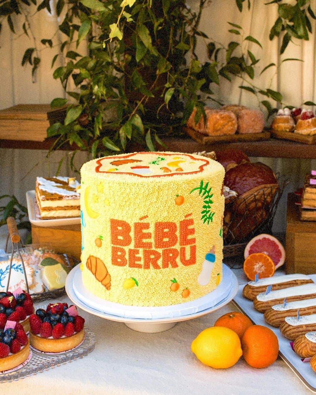 ジュリー・サリニャーナのインスタグラム：「BABY SHOWER CAKE & PATISSERIE STAND🎂🥐 Sharing our cake x pastries details: I was so in love with our beautiful carrot cake that my go-to cake girl @alanajonesmann made for our special day! I wanted to have baby and Mediterranean/French elements on the cake like croissants, baby bottles, olive branches, oranges, lemons etc- The details were impeccable of each element and I literally screamed when I saw how cute the cake turned out! 🥹  I wanted to have a patisserie stand at the shower and bring a bit of France to LA with all of my favorite French pastries like almond croissants, macarons, eclairs, beignets, baguettes, etc! We had cute to-go boxes for guests to take pastries home as if you were at a French bakery! My favorite pastries in LA are from @bottegalouie so I knew our pastries had to be from there! We built the cute awning and created my dream French Al-fresco patisserie stand!   Thank you so much to @bottegalouie for all the beautiful pastries and @alanajonesmann for the dreamiest babyshower cake- you guys made my shower a dream come true! I’m over the moon with how everything tasted and turned out! 💛 #babyshower #patisserie #babyshowercake   Photography by @elli_lauren」