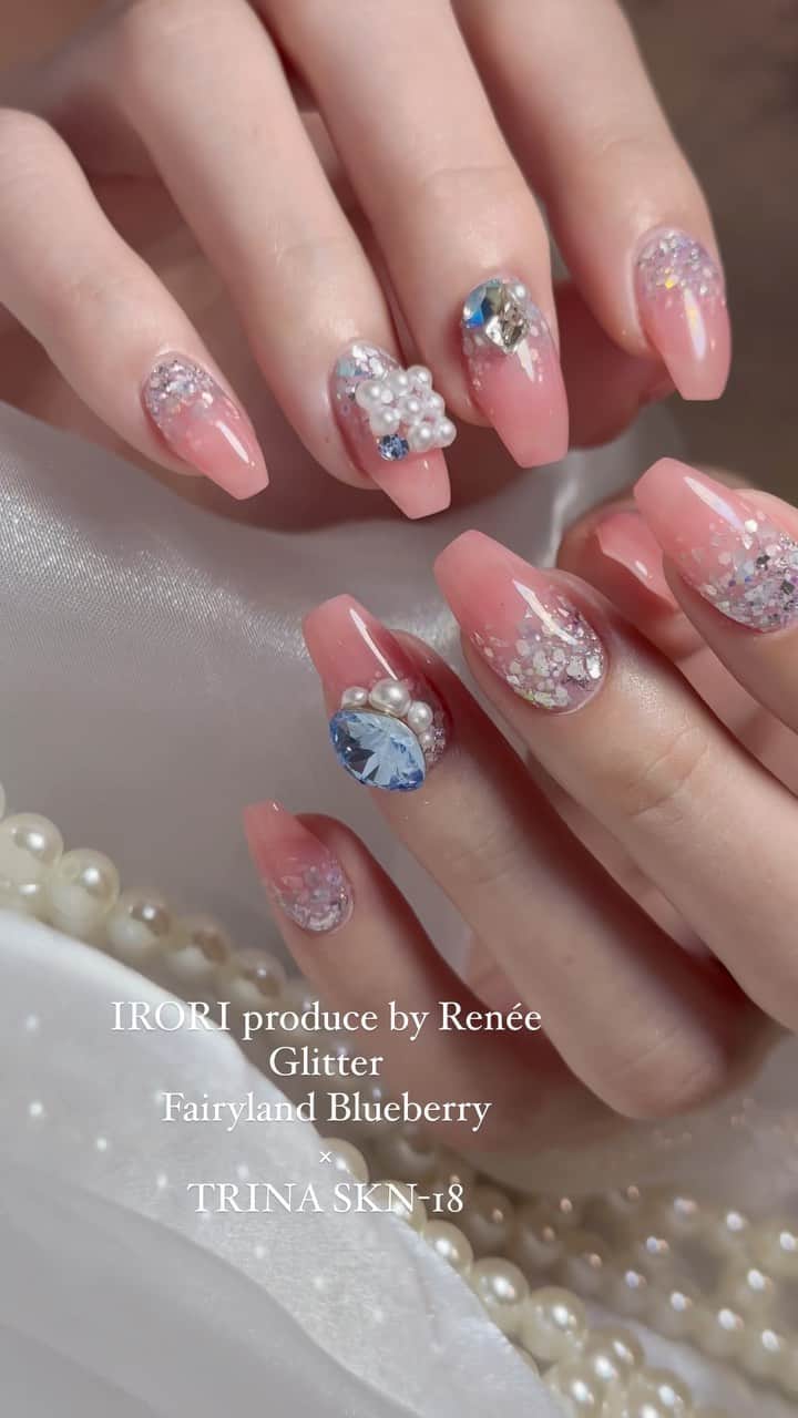 埜藤理恵のインスタグラム：「プロデュースグリッター1番人気カラー✨ ブルーやパープルにホワイトが少し混ざってるから 絶妙なふわっと感が出る✴︎ ブルーが強く見えがちだけど 爪に乗せると馴染む♪ @smint_product サイトより購入できます👐🏻  カラーは @trinagel_official の SKN-18  @dnagel_spacenail  base gel fillbase top gel Diamond top   ピンクにブルーストーンが可愛い！✴︎  □ Rie Nofujiプロデュース @tree01official エプロン 好評発売中  □ Renée professional brush シリーズ ＊オーバル ＊トップフレンチ ＊スマートフラット Renée web shop 全国ネイルディーラーにて発売中 プロフィールURLより飛べます  □ 店舗詳細 ⇩ 大阪府大阪市北区堂山町1-2 R&Eビル3階 am10:00〜pm20:00 JR大阪駅から徒歩7分 阪急梅田駅から徒歩7分 御堂筋梅田駅から徒歩7分  ご予約は サロンの公式LINEより受け付けております。 @rrieenee プロフィールURLより LINE飛べます。 LINEにて行き方動画も配信しておりますので ご参考くださいませ」