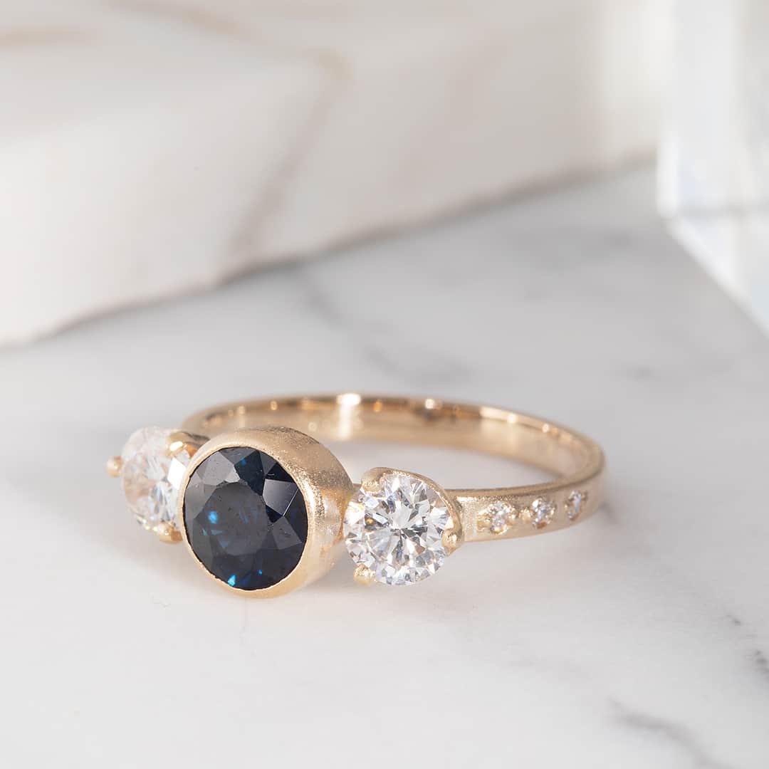 シェイスビーのインスタグラム：「A custom three-stone ring featuring our customer's heirloom blue sapphire and diamond accents. Click the link in our bio to schedule your custom appointment.」