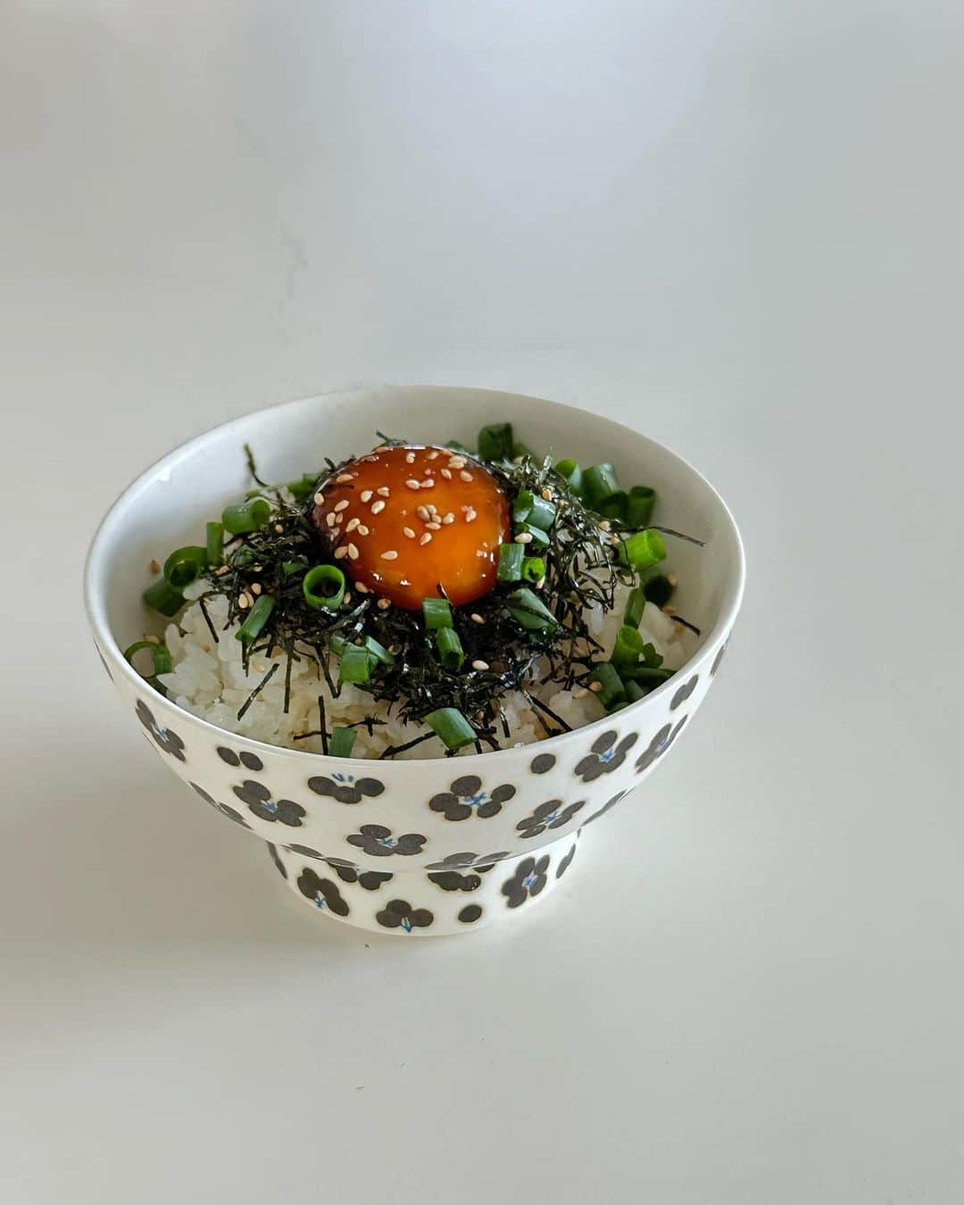 のインスタグラム：「卵黄を寝る前にお醤油、みりん、麺つゆに漬けて、翌朝ほかほかご飯の上にのせた🍚  久しぶりに朝ごはん。幸せです。ねぎ、海苔、白胡麻あたりを適当にかけました。  それにしても3枚目の動画の手が震え過ぎて話にならないです。」