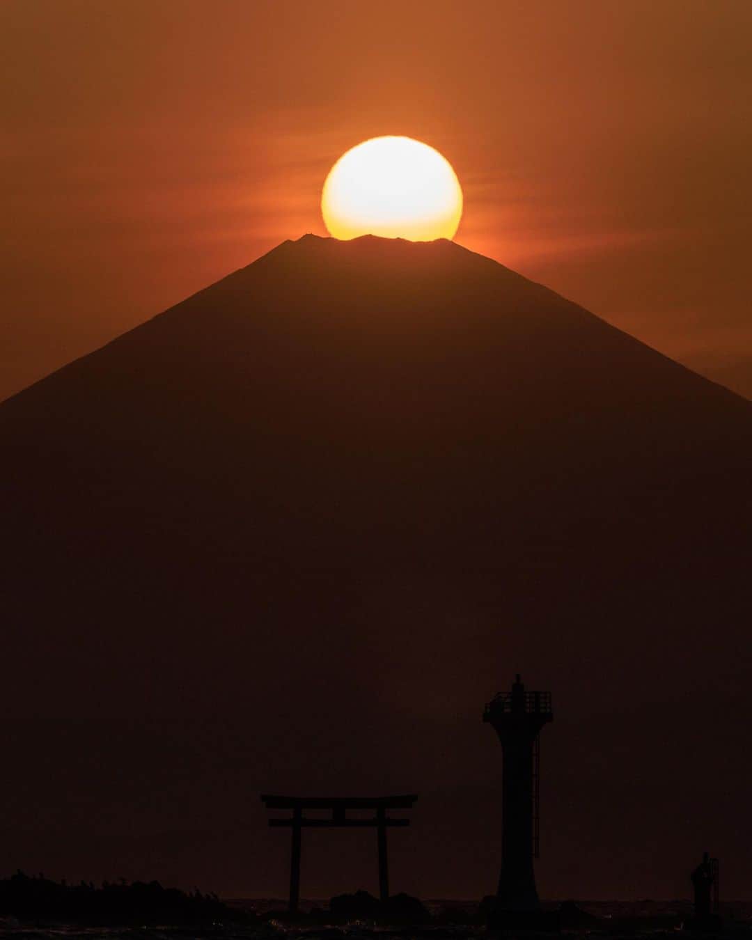 SHOCK EYEさんのインスタグラム写真 - (SHOCK EYEInstagram)「その瞬間は無言のままシャッターを押し続けてた。  森戸神社の鳥居と富士山と太陽が一直線に重なる瞬間✨ それは年に2回しか訪れない。  しかも天候の影響も大きいので、本当に巡りあえるか、、  そんな中、撮影できたダイヤモンド富士💎🗻  葉山から臨むダイヤモンド富士は、富士山の近辺で撮るソレとは違い、めちゃくちゃ太陽が大きくて、本当に神々しかった🙏✨🗻  先週の稲村ヶ崎からの撮影では、お目にかかることができなかったから、なおさら嬉しくて、、 めちゃくちゃ感動したよ。  そんな奇跡の写真を皆にシェアするね😊  #ダイヤモンド富士 #富士山 #森戸海岸 #森戸大明神 #mtfuji」4月11日 11時13分 - shockeye_official