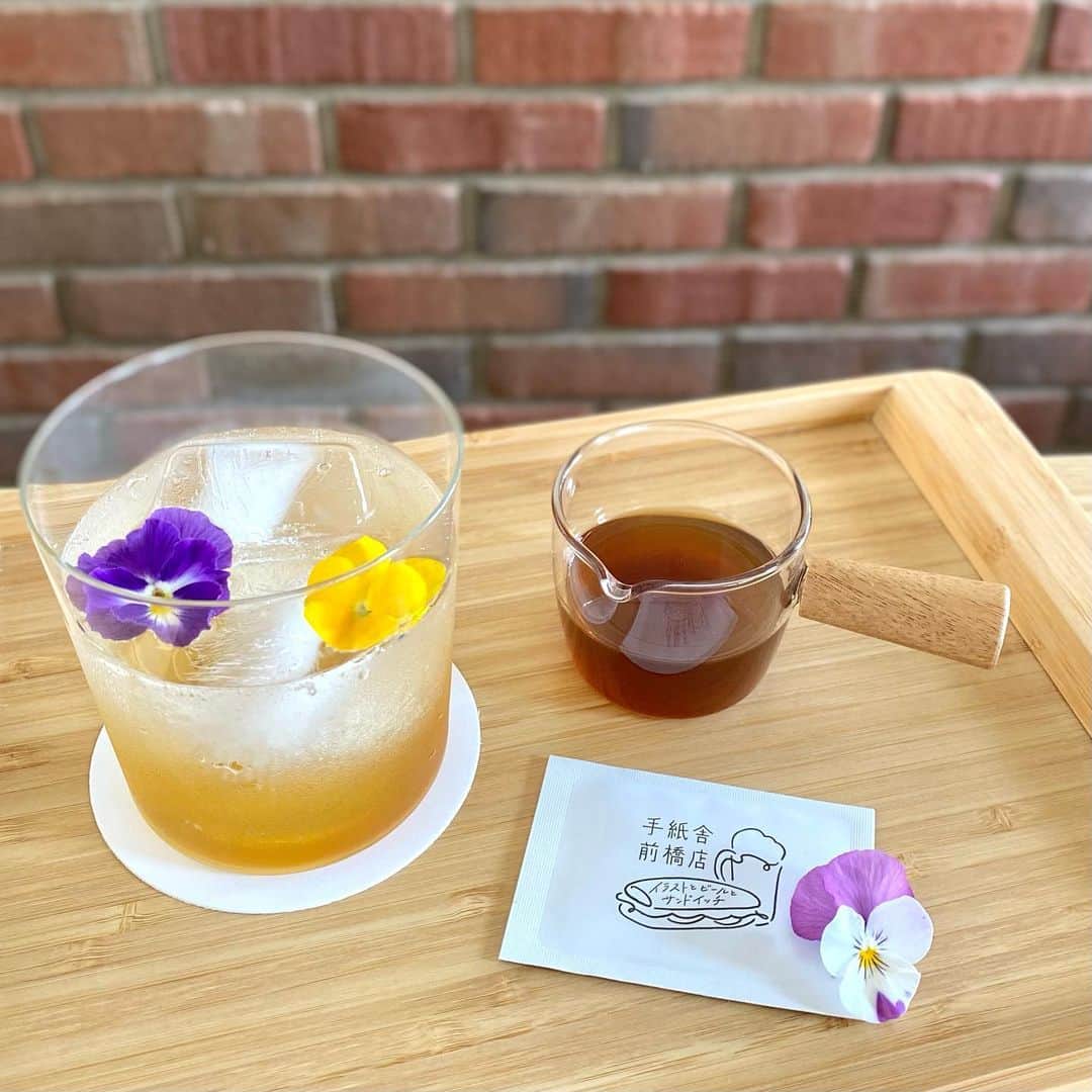 手紙社のインスタグラム：「【手紙舎 前橋店】 本日より砂糖ゆき展「春風とキッチン」をイメージした特別ドリンクメニュー「カモミールのコーディアルシロップ」がスタートしました。季節の変わり目に心と体をリラックスさせるお花のハーブドリンクです。ソーダ、水、お湯と割り方をお選びいただけますので、ぜひお好みの飲み方でお楽しみください。  【砂糖ゆき「春風とキッチン」 at 手紙舎 前橋店】 期間：2023年4月12日（水）～5月7日（日） 会場：イラストとビールとサンドイッチ 手紙舎 前橋店 住所：群馬県前橋市千代田町2丁目10-2 comm 1F・B1F 営業時間：1F）ビアスタンド 11:00～20:00（19:30LO） 　　　　　B1F）雑貨店　　  11:00～18:30 定休日：月・火 ＊祝日は営業（翌日振替休） 問い合わせ：027-212-8183  2023.4.12  # 手紙舎#手紙舎前橋店#前橋カフェ#カモミール#コーディアルシロップ#エディブルフラワー#ドリンク」