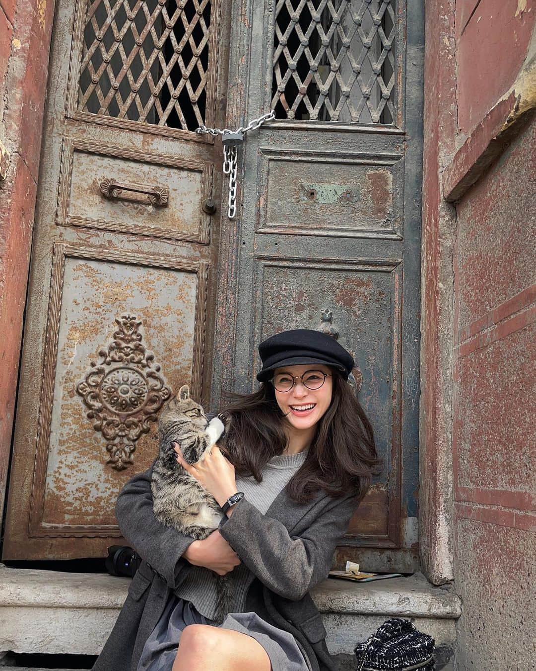 fukishaljのインスタグラム：「🐈❤️🙏🏻  今回の旅で1番想い出の🐈ちゃん！ お散歩中に出逢って 膝の上に登ってきてくれたの！ そろそろ帰ろうとすると 「降りたくない😾」って体から離れなくて連れて帰りたくなる程可愛かった…😿  日本から持ってきたレモンのお気に入りのおやつすごく気に入ってくれた☺️  この日のコーディネートはグレーでまとめました🩶」