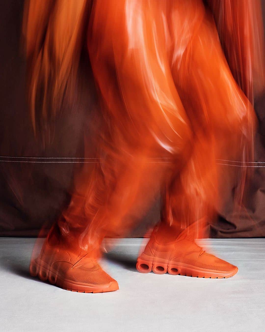 サルヴァトーレ・フェラガモのインスタグラム：「MOVING FORWARD. ORANGE TECHNICAL KNIT AND SUEDE. #FERRAGAMOSS23 #FERRAGAMOSNEAKERS」