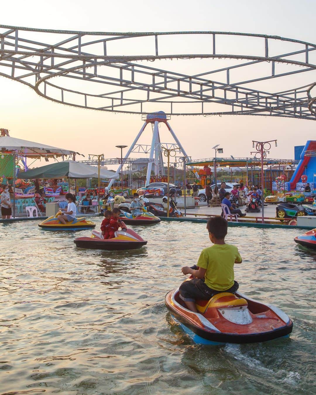 Shunsuke Miyatakeのインスタグラム：「Amusement park at dusk /  When was the last time you visited an amusement park at dusk in Cambodia? Children were enjoying themselves on small duck boats in the beautiful sunset.  It is such a joy to see children so absorbed in something. Siblings paddle, and some children row alone. Careful not to fall out of the boat.  To be absorbed in something, perhaps it is to learn desperately. As adults, it is difficult to learn something new. I want to be a person who enjoys learning something new, no matter how small.  #phnompenhphotographycollective #PhnomPenh #PPPC #Cambodia」