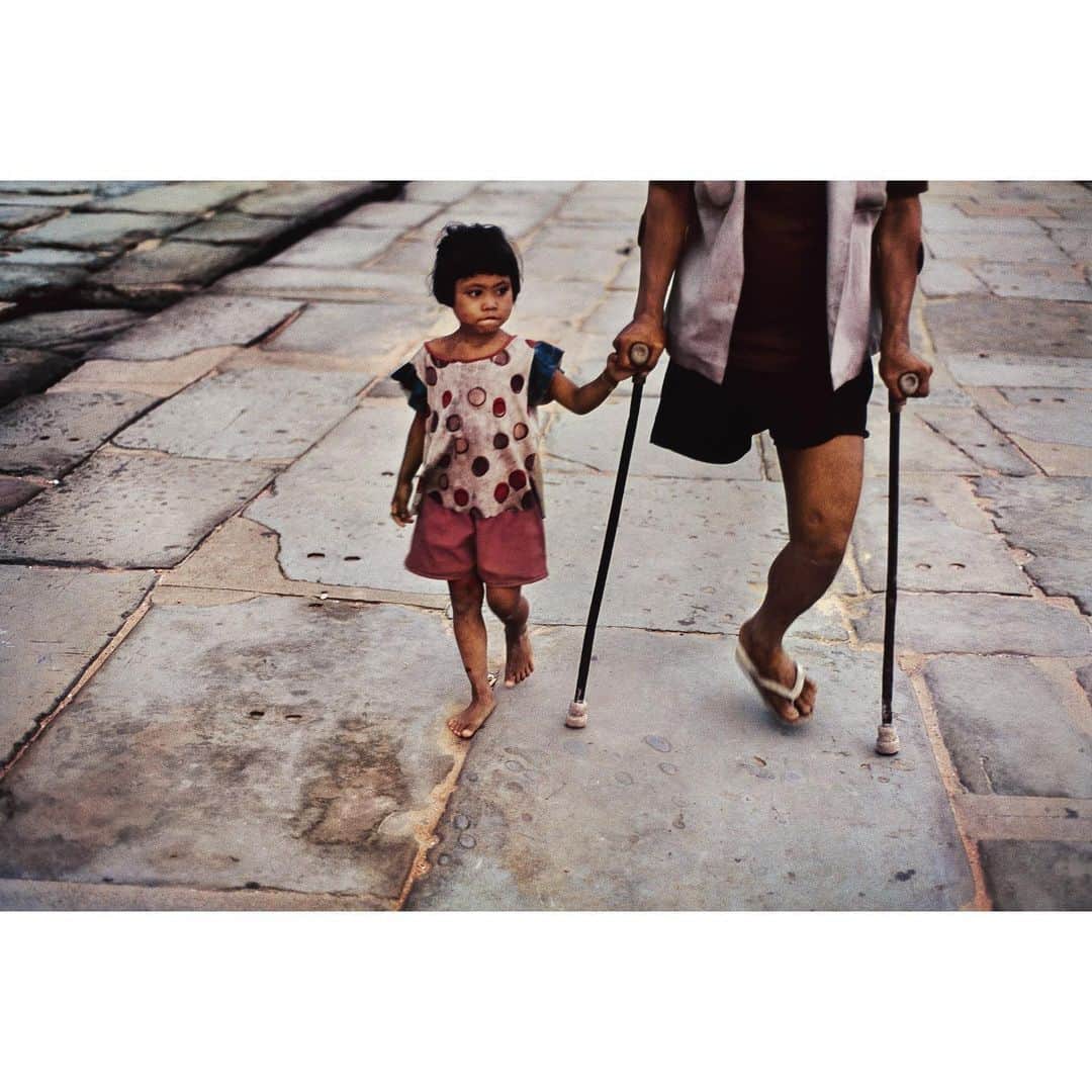 スティーブ・マカリーのインスタグラム：「A girl walks with her father who was wounded during the conflict with Vietnam. Angkor Wat, Cambodia, 1999.」