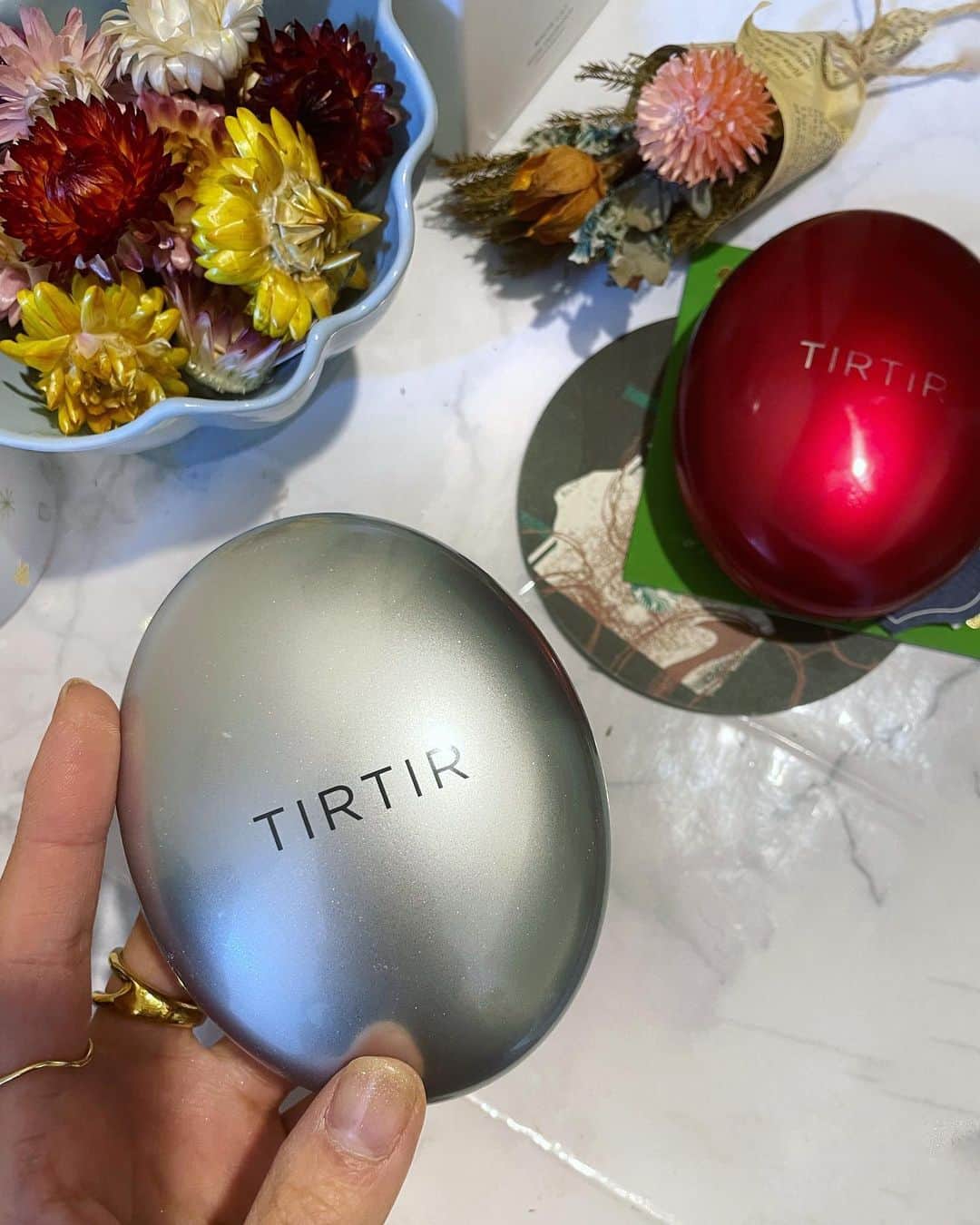 のインスタグラム：「. 私がいつも愛用しているTIRTIRのクッションファンデからついに新作がてたぁ🥹💓  TIRTIRのクッションファンデは ☑カバー力ありつつツヤ感ある ☑乾燥肌の私でも乾燥せず持続力抜群 ☑トーンアップ ☑密着して崩れにくい  全て揃ってて、赤をずっと愛用していたんだけど、、、  今回の新作はそれに加えてさらに透明感増した感じ✨  もうこれは、赤から新作に速攻乗り換えよ〜🕊🤍  . #TIRTIR #マスクフィットオーラクッション #sponsored  #最強ベース #マスクフィット #マスクフィットシリーズ #カバー力 #韓国コスメ #韓国コスメ購入品 #韓国コスメレビュー」