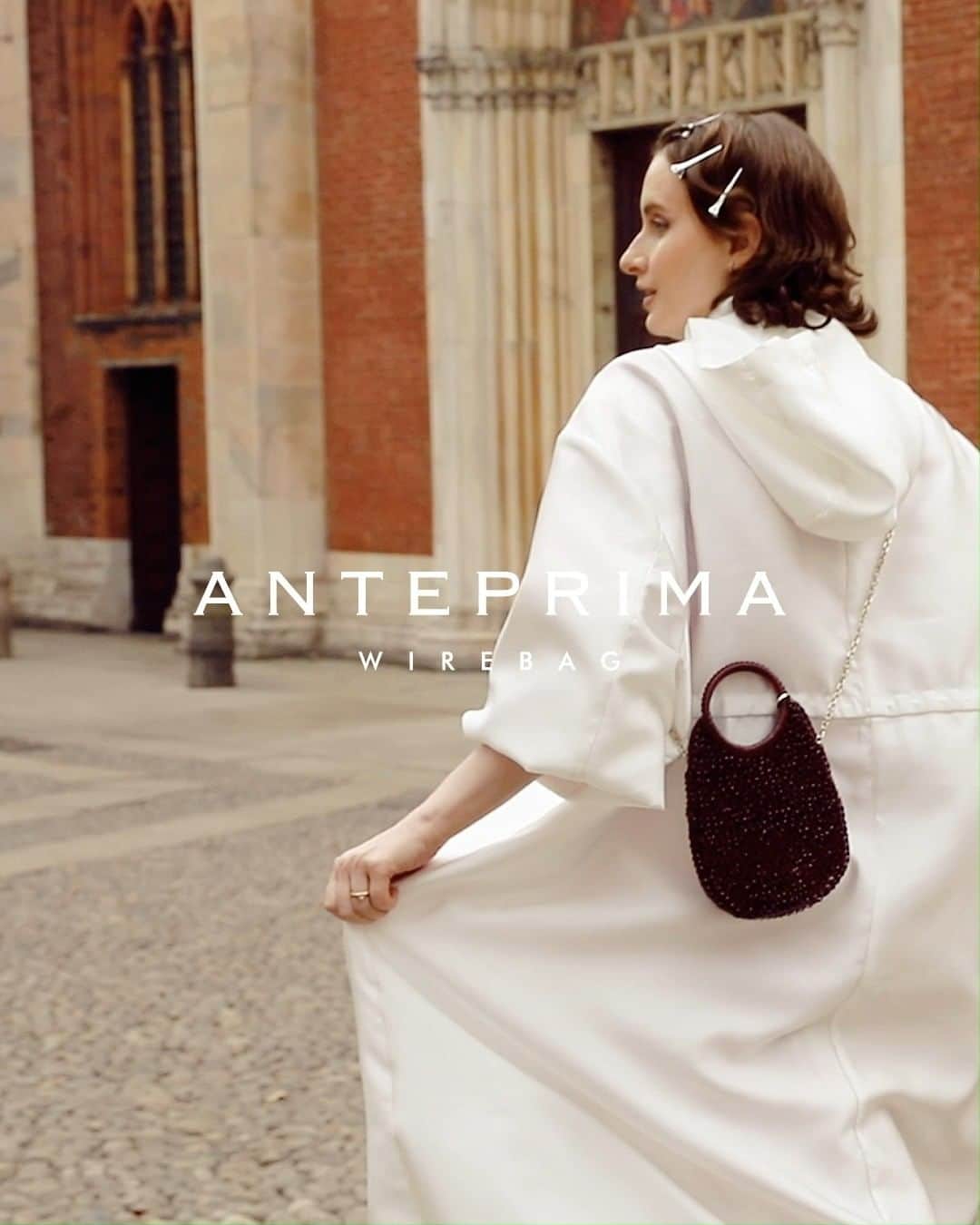 ANTEPRIMAのインスタグラム：「Velvety Statement.  Pampering yourself in a full swing of Milanese aura, @gruzinaolga brought you to the historical Brera in Milan. The burgundy red STANDARD #WIREBAG with the #ANTEPIRMA #SS23 Bianco Jacket saturated this imitative city with delicacy.   Shop the STANDARD WIREBAG now.  #ANTEPRIMA30 #SpringSummer2023 #SS23 #ANTEPRIMA #WIREBAG #MilanStyle #Milan #MilanFashion #Miniature #MicroBag #MiniBag #CraftBag #CrochetBag #Handcraft #KnitBag #WorkBag #ItalianDesign #Craftmanship #アンテプリマ」