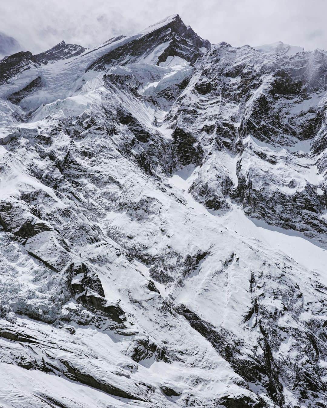 石川直樹さんのインスタグラム写真 - (石川直樹Instagram)「#Annapurna from the crampon point, #Nepal. 今日はクランポンポイントまで体慣らし。写真は、4500m地点から眺めたアンナプルナI峰。2枚目の写真が、山の左側にある懸垂氷河。この懸垂氷河の左を登って右に回り込み、右上方にトラバース、最後にフレンチクーロワールを400m登った先が頂上だという。 岩波少年文庫（近藤等訳）によれば、#アンナプルナ はネパール語で「収穫の女神」。地図を見ていると、アンナプルナ山群が無数の小さな川の水源になっていることがわかる。この氷河から流れ出た水が周囲の村を潤し、人々に恵みをもたらしてきたのは間違いない。 しかし、一方でこの山は「キラーマウンテン」というありがたくないニックネームも持つ。それはルート上で雪崩が多すぎて、これまで多くの遭難を引き起こしてきたからだ。昔、ミンマに14の山でどれが一番難しいと思うか、と尋ねたところ、即答でアンナプルナだった。 雪崩のリスクの少ない迂回ルートが近年になって新しく拓かれたことで、2021年には記録に残る大量の登頂者もだした。だが、それでも不安は残る。アンナプルナとは、そういう山だ。 . #Himalayas#Glacier」3月24日 18時06分 - straightree8848