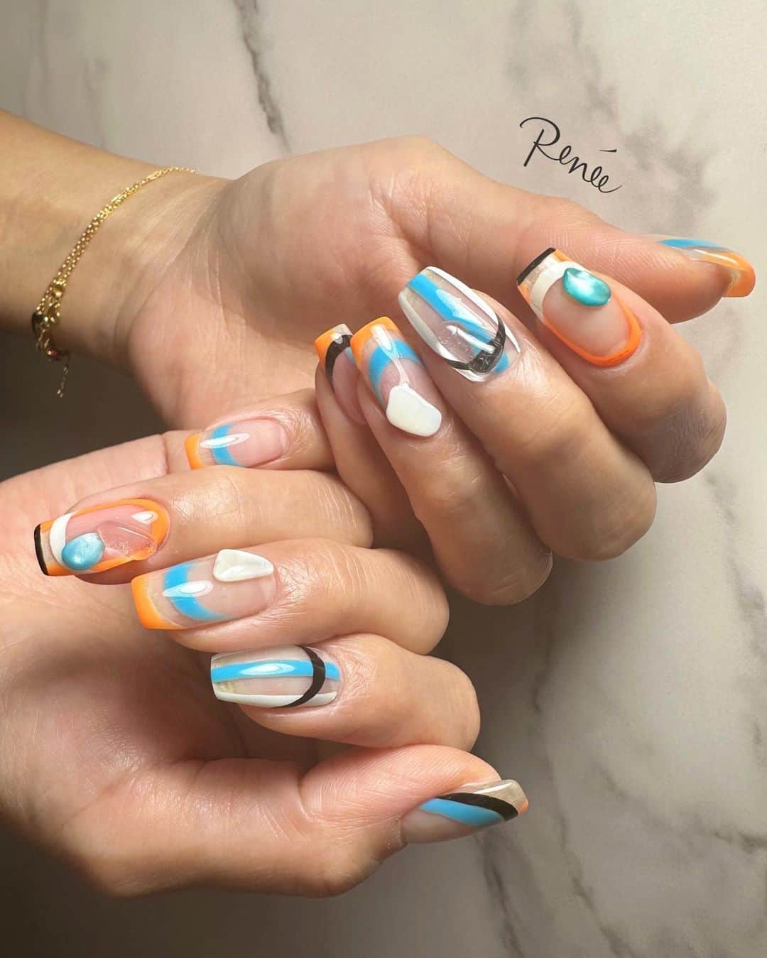 埜藤理恵のインスタグラム：「春トレンドのブルー🐬 お任せデザイン♪ ネオンオレンジとの 組み合わせ相性抜群♡  □ Rie Nofujiプロデュース @tree01official  エプロン 好評発売中  □ Renée professional brush シリーズ ＊オーバル ＊トップフレンチ ＊スマートフラット Renée web shop 全国ネイルディーラーにて発売中 プロフィールURLより飛べます  □ 店舗詳細 ⇩ 大阪府大阪市北区堂山町1-2 R&Eビル3階 am10:00〜pm20:00 JR大阪駅から徒歩7分 阪急梅田駅から徒歩7分 御堂筋梅田駅から徒歩7分  ご予約は サロンの公式LINEより受け付けております。 @rrieenee プロフィールURLより LINE飛べます。 LINEにて行き方動画も配信しておりますので ご参考くださいませ」