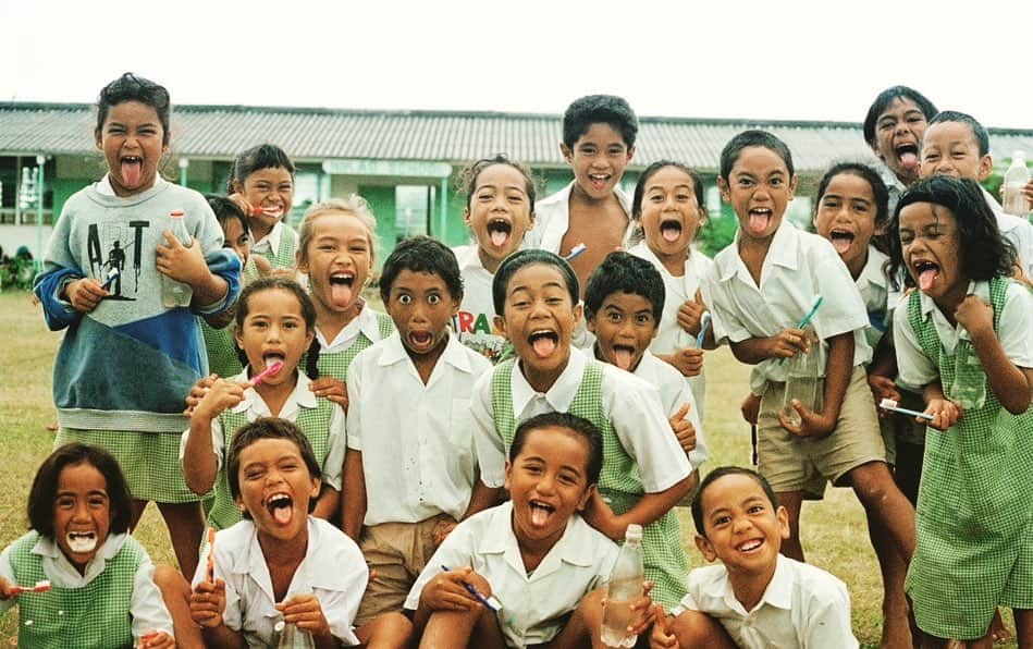 ポール・ブラックソーンのインスタグラム：「Pictures from the attic. Rarotonga, in the Cook Islands, in the South Pacific. 1996. There I was cycling around the island when I came across these great kids brushing their teeth in the school field. I got my camera out and they all came running up to me… “Can you all pull funny faces?” I asked, and they duly did. These kids have brought a smile to my face for years… #filmphotography #travelphotography」