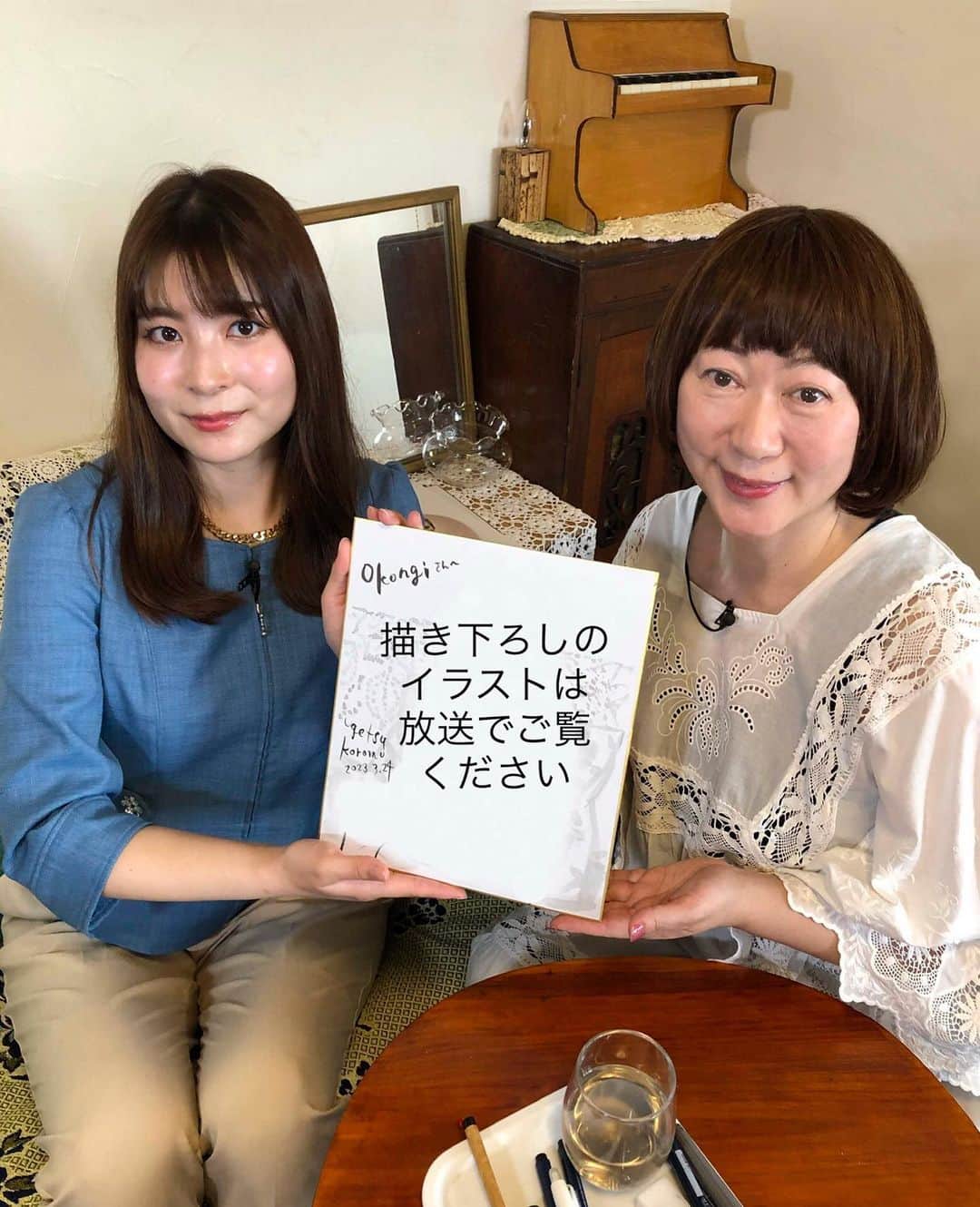 雨月衣のインスタグラム：「一昨日、私のアトリエでテレビの撮影が行われました。群馬テレビアナウンサーの小此木さんにインタビューしていただき色々お話しさせていただきました。 群馬テレビのいくつかの報道番組のコーナーでちょこっとだけ出させていただく予定です。  放送日はまだ未定、後程インスタなどでお知らせします。  写真一枚目、 小此木さんと私。 手にしているのは現場で描いた絵ですが、なにを描いたか全貌は放送でお楽しみください。  お話は楽しく色々引き出してくれた小此木さんは素晴らしかったのですが、色々と残念な私……  写真後ろのガラスの器に 花を飾ろうとしていて時間がなくて飾れなかった！残念！  写真２枚目、 ガラスの器(金魚鉢)に飾ろうとしていたベランダで咲いていた白椿。  模様替えしてカフェコーナーを作ったので中国茶を入れようと一式用意していたけど、当日は暑くてお茶の気分ではなかったので冷蔵庫に常備しているアップルタイザーをお出ししました。 そこで、カメラマンさんにお出ししたアップルタイザーのボトルを自分のものと間違えて飲み干すという失態！すんません！  写真3枚目、 ベトナムのランタン吊るして、茶器類や茶葉を並べた茶箪笥を仕事場の一角に設置。 今日は寒いので中国茶飲んでます。  写真４枚目、 撮影時間帯14:00〜16:00頃に晴れていれば部屋にスペクトルな日差しをもたらし素敵な効果を生み出したであろう、天井に近い小窓に吊るしたガラスのオーナメント。しかし曇っていて日差し入らず。残念！  写真5枚目、 パンダ🐼にも茶をあげてみました。ちっちゃい茶器に注いでます。見えますか？  そ・し・て…… 今気がついたのですが、 小此木さんに描いた絵に 「Okonogiさんへ」と書いたつもりが「Okongiさんへ」となっている〜！　 写真６枚目。  おこんぎさん　て…… ご、ごめんなさい！  そんな失態も含めて 放送を楽しんでいただければ幸いです。  あ、それから 仕事の様子を撮ってもらっている時おそらく映り込んでいるデスクスタンドの傘がものすごく邪魔ったと思う。しかもスタンドだけ埃を取りきれて無かった。他は全部綺麗に掃除したのに何故かあれだけ埃まみれ……しかも一番無駄に目立つ位置にあるという…… ざ、残念！！  #ニュースeye8 #小此木佑香　アナ #雨月衣仕事」