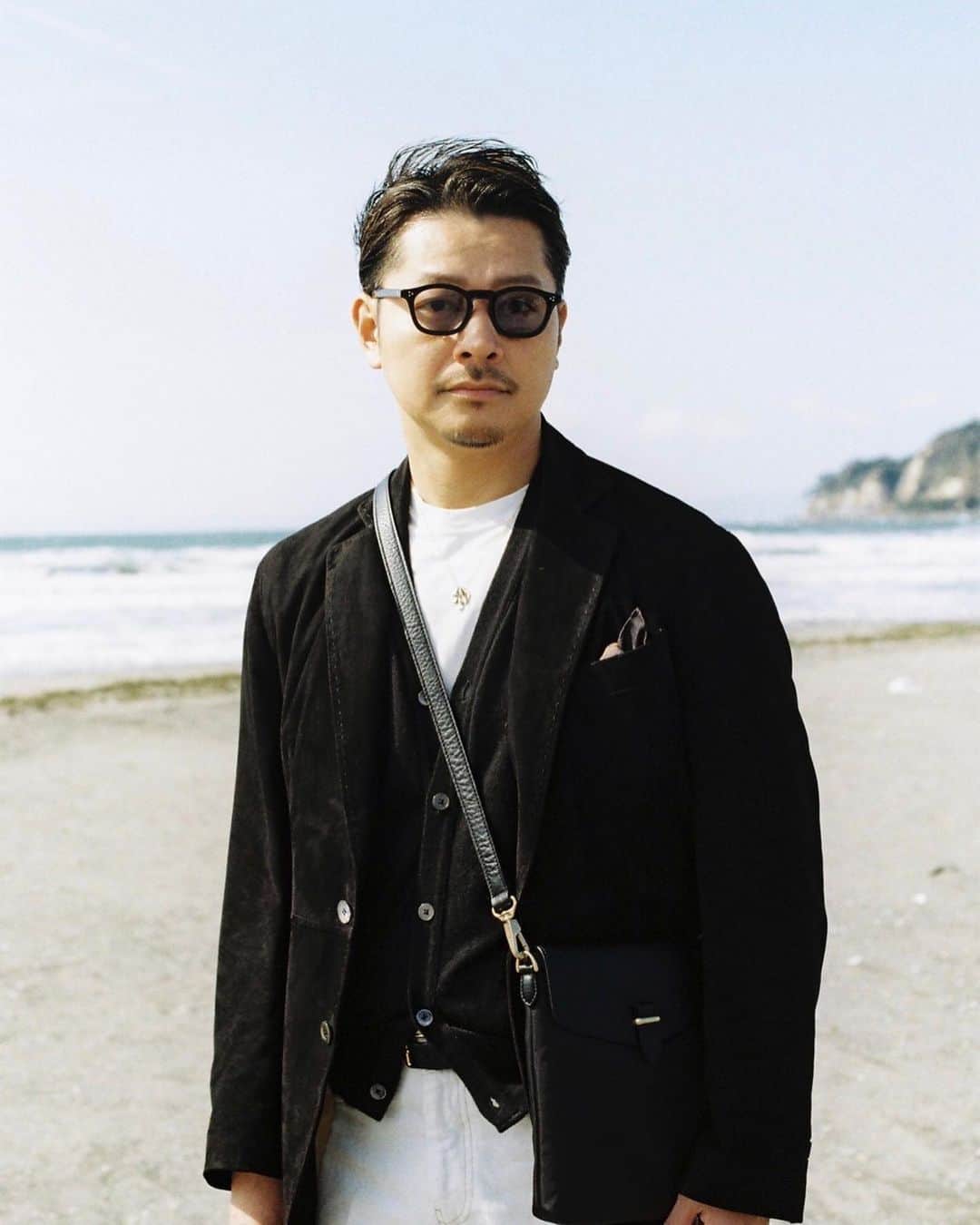高田朋佳のインスタグラム：「オンショア強めの海岸で。 Pelle Morbidaさんの10周年コラボ企画の第二弾。 現代にファーストエイドポーチを落とし込んだ時に、iPhoneやコンパクトウォレットなどの必需品が収まるサイズを狙ったサイズ感で作って頂きました。 バックパック同様にリサイクルナイロンxレザーのコンビが程よく着こなしのアクセントになります。  #pellemorbida #wearlness #10thanniversary #mensbag #shoulderbag #mensfashion」