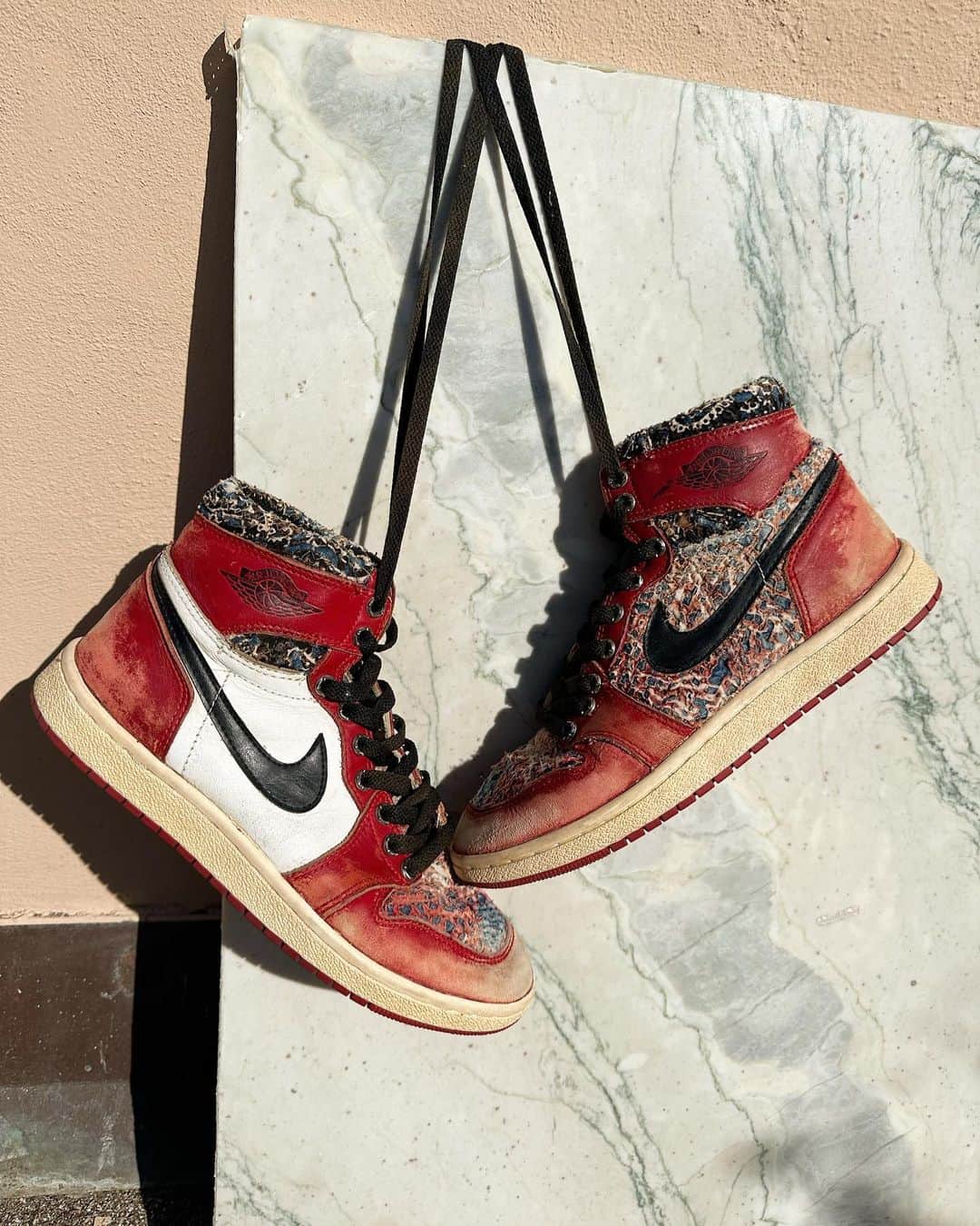 小木 "Poggy" 基史のインスタグラム：「A not-for-sale art piece “KINTSUGI SNEAKER” @foxtrott_uniform & @proletareart and curated by Poggy. シンガポールのブランドFoxtrot Uniformが、ボロボロのスニーカーをバンダナでリメイクしていたのですが、それをPROLETA RE ARTと一緒に出来ないかと相談を受けたのが約1年前でした。何度もやり取りをして、ヴィンテージスニーカーのアップサイクラーとヴィンテージデニムのアップサイクラーが共鳴し、非売品のアートピースを作ろうということになりました。 PROLETA RE ART側がヴィンテージバンダナに様々な生地を何枚も重ね丁寧に手作業で加工して作った素材をFoxtrotに送り、履けなくなってしまったボロボロの85年のJORDAN1を手作業で分解し、その生地を使用し再構築しています。それを最終的にPROLETA RE ARTが全体にヴィンテージ加工を施し、質感を加速させています。縫製糸が擦り切れないように極限まで繊細に手作業でシェービングやフェイド作業を駆使した、極めて手の込んだKINTSUGI SNEAKER。  ※KINTSUGIとは、欠けたり割れたりしてしまった器を主に漆と金粉を使って修復する日本の伝統技術のことです。 金繕い、金直しとも呼ばれ、金粉を蒔いて仕上げをすることで、継ぎ目がまるで新たな模様のようになり、世界にひとつしかない特別な器になります。  ボロボロになった素材をアップサイクルして新たなアートピースに昇華する両者が、ヴィンテージジョーダンに新たな命を吹き込みました。将来的にはお客様が履けなくなってしまったスニーカーをこういった形でアップサイクルできるようなプロジェクトにできたら良いですねと話しています。  “A not-for-sale art piece co-produced by a vintage sneaker upcycler and a vintage denim upcycler”  “Vintage sneakers and Boro cloth have a special charm for us- it’s a love that might be unconditional.   Despite what some may say about them being outdated, We see life in these shoes and Boro cloth.  Their scuffs, creases, and tears each tell a unique story and only add to their beauty.   With Kintsugi sneakers, We take the 15th-century Japanese philosophy of repairing with gold to bring these vintage shoes back to life and celebrate their flaws.   Join me in embracing imperfections and finding beauty in them.   brought to you by  Foxtrot Uniform & PROLETA RE ART and curated by Poggy.”」