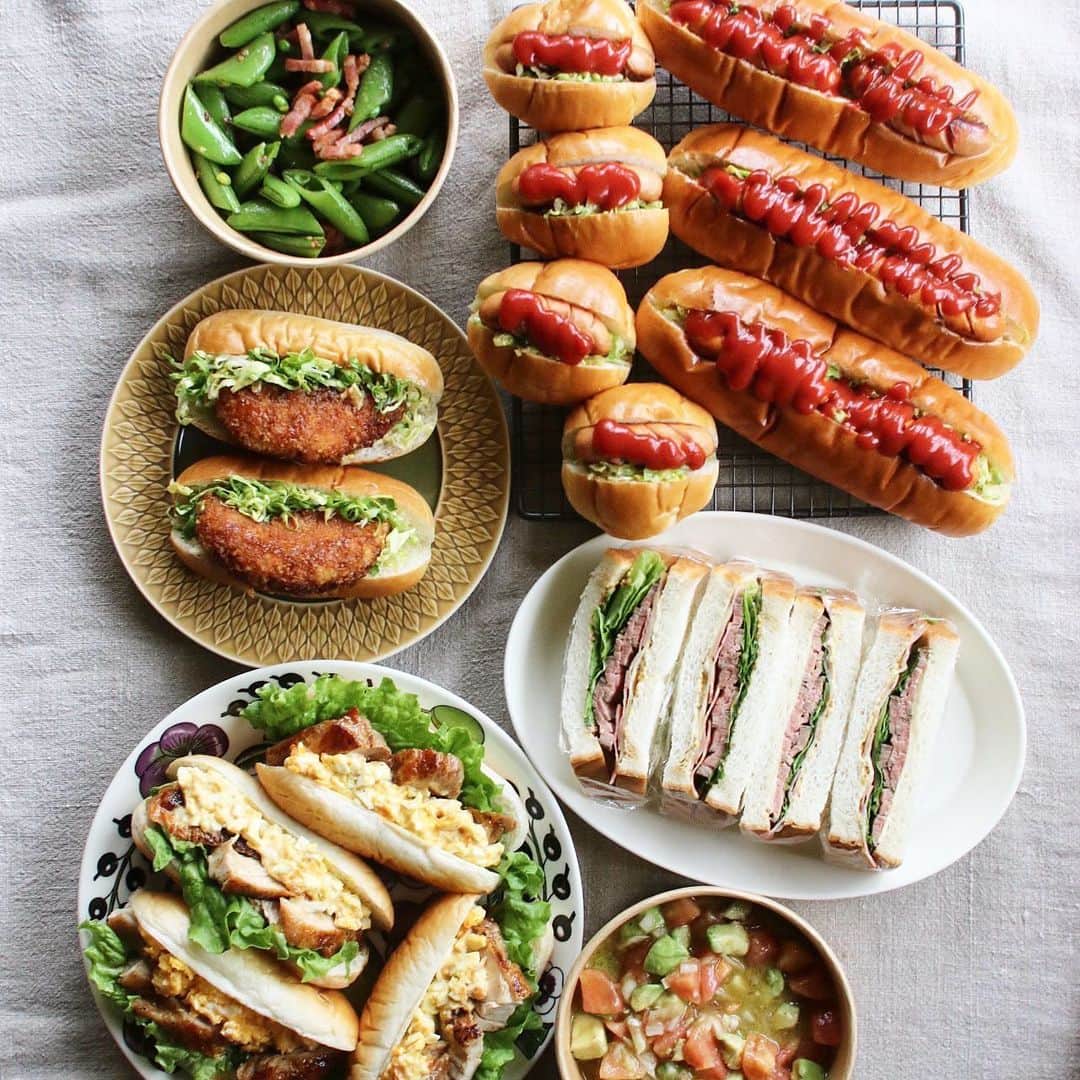 Atsukoのインスタグラム：「今日のお弁当 2023.03.28  ホットドック 照り焼きチキンサンド コロッケサンド ローストビーフサンド スナップエンドウとベーコンのペペロン アボカドとトマトと新玉ねぎのサラダ  娘が友達の引越し手伝うみたいなので差し入れ用と実家用と自分のお弁当用。  ローストビーフは和牛のお肉が売ってなくて、オージービーフでやったけど、低温調理したので柔らかくて美味しくできた！ スナップエンドウはかわい子ちゃんのご実家からの差し入れ。 そら豆も沢山頂いたので食べるのめちゃくちゃ楽しみ🤣 そら豆とホタルイカでパスタにしようか、アヒージョもいーなー🤤」