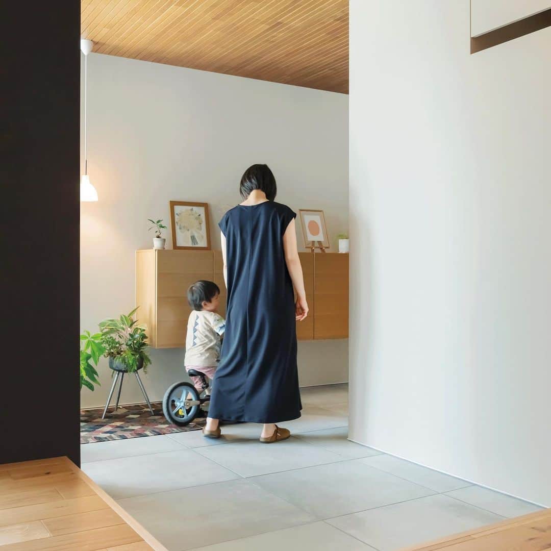 住友林業株式会社_戸建住宅公式さんのインスタグラム写真 - (住友林業株式会社_戸建住宅公式Instagram)「本日は、空間を緩やかにつなげる土間のある#平屋 のオーナー様宅のご紹介！  大判タイルと木質天井で、シンプルに仕上げた美しいエントランス。 玄関ドアを開けると#テラス とつながった奥行きのある土間空間が広がります。 折下げ天井と軒天井の材の幅を揃えて空間をひとつながりに見せることで、内と外のつながりを演出します。 さらに天井だけでなく、土間とテラスも同じ素材でフラットに。  玄関の上がり口を広く取っている為、買い物帰りに荷物を下ろすのにも便利です。 玄関脇には、洗面コーナーにつながる#裏動線 を兼ねたエントランスクローク。 靴だけでなく、ベビーカーやゴルフバッグなども収納できます。  窓越しに田園風景を望むリビング。玄関土間と一体となって開放感と奥行きのある佇まいです。 シンプルな内装に床の#オーク が木の温もりを添えています。  家の中心にダイニングキッチンを配置して、家事がしやすい#回遊動線 としています。 玄関やリビングから見えない位置に水まわりや収納を設けることで、効率的な#家事動線 を実現。 家事全般が楽になり、お子様と過ごす時間も増えたそうです。  外観はシンプルな寄棟に白い吹付で仕上げました。 深い軒にすることで、冬は日差しを採り入れつつ、夏の強い日差しをさえぎります。 さらに軒がつくる影のおかげで、外から室内を見えにくくする効果もあります。  *……*……*……*……*……*……*……*……* 住友林業の最新人気実例集「自家自讃vol.147」に 掲載されているオーナー様宅。  実例集「自家自讃」では、間取りやオーナー様の生の声を掲載しています！ ぜひ資料請求の上、ご自宅でお楽しみください。  @sfc_ie ハイライト"最新実例集"から無料でお届けしています！ *……*……*……*……*……*……*……*……*  #住友林業  #住友林業の家  #すみりん  #すみりんの家  #家づくり  #新築一戸建て  #注文住宅  #自由設計  #自由設計の家  #木の家  #木のある暮らし  #理想の家づくり  #ていねいな暮らし  #空間コーディネート  #ルームツアー  #空間デザイン  #こだわりの家  #玄関インテリア  #TREEing #森を育てる家」3月28日 18時56分 - sfc_ie