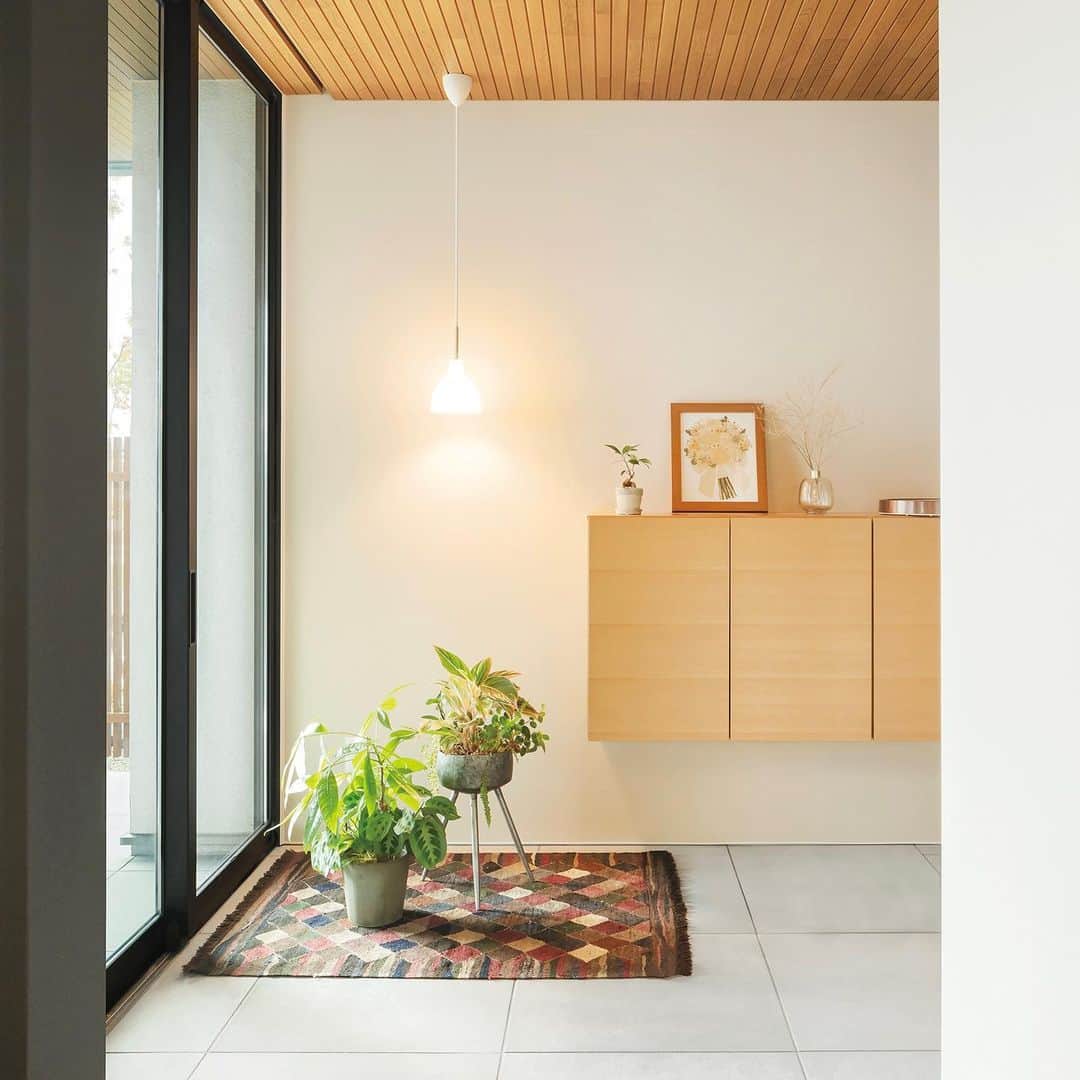 住友林業株式会社_戸建住宅公式さんのインスタグラム写真 - (住友林業株式会社_戸建住宅公式Instagram)「本日は、空間を緩やかにつなげる土間のある#平屋 のオーナー様宅のご紹介！  大判タイルと木質天井で、シンプルに仕上げた美しいエントランス。 玄関ドアを開けると#テラス とつながった奥行きのある土間空間が広がります。 折下げ天井と軒天井の材の幅を揃えて空間をひとつながりに見せることで、内と外のつながりを演出します。 さらに天井だけでなく、土間とテラスも同じ素材でフラットに。  玄関の上がり口を広く取っている為、買い物帰りに荷物を下ろすのにも便利です。 玄関脇には、洗面コーナーにつながる#裏動線 を兼ねたエントランスクローク。 靴だけでなく、ベビーカーやゴルフバッグなども収納できます。  窓越しに田園風景を望むリビング。玄関土間と一体となって開放感と奥行きのある佇まいです。 シンプルな内装に床の#オーク が木の温もりを添えています。  家の中心にダイニングキッチンを配置して、家事がしやすい#回遊動線 としています。 玄関やリビングから見えない位置に水まわりや収納を設けることで、効率的な#家事動線 を実現。 家事全般が楽になり、お子様と過ごす時間も増えたそうです。  外観はシンプルな寄棟に白い吹付で仕上げました。 深い軒にすることで、冬は日差しを採り入れつつ、夏の強い日差しをさえぎります。 さらに軒がつくる影のおかげで、外から室内を見えにくくする効果もあります。  *……*……*……*……*……*……*……*……* 住友林業の最新人気実例集「自家自讃vol.147」に 掲載されているオーナー様宅。  実例集「自家自讃」では、間取りやオーナー様の生の声を掲載しています！ ぜひ資料請求の上、ご自宅でお楽しみください。  @sfc_ie ハイライト"最新実例集"から無料でお届けしています！ *……*……*……*……*……*……*……*……*  #住友林業  #住友林業の家  #すみりん  #すみりんの家  #家づくり  #新築一戸建て  #注文住宅  #自由設計  #自由設計の家  #木の家  #木のある暮らし  #理想の家づくり  #ていねいな暮らし  #空間コーディネート  #ルームツアー  #空間デザイン  #こだわりの家  #玄関インテリア  #TREEing #森を育てる家」3月28日 18時56分 - sfc_ie