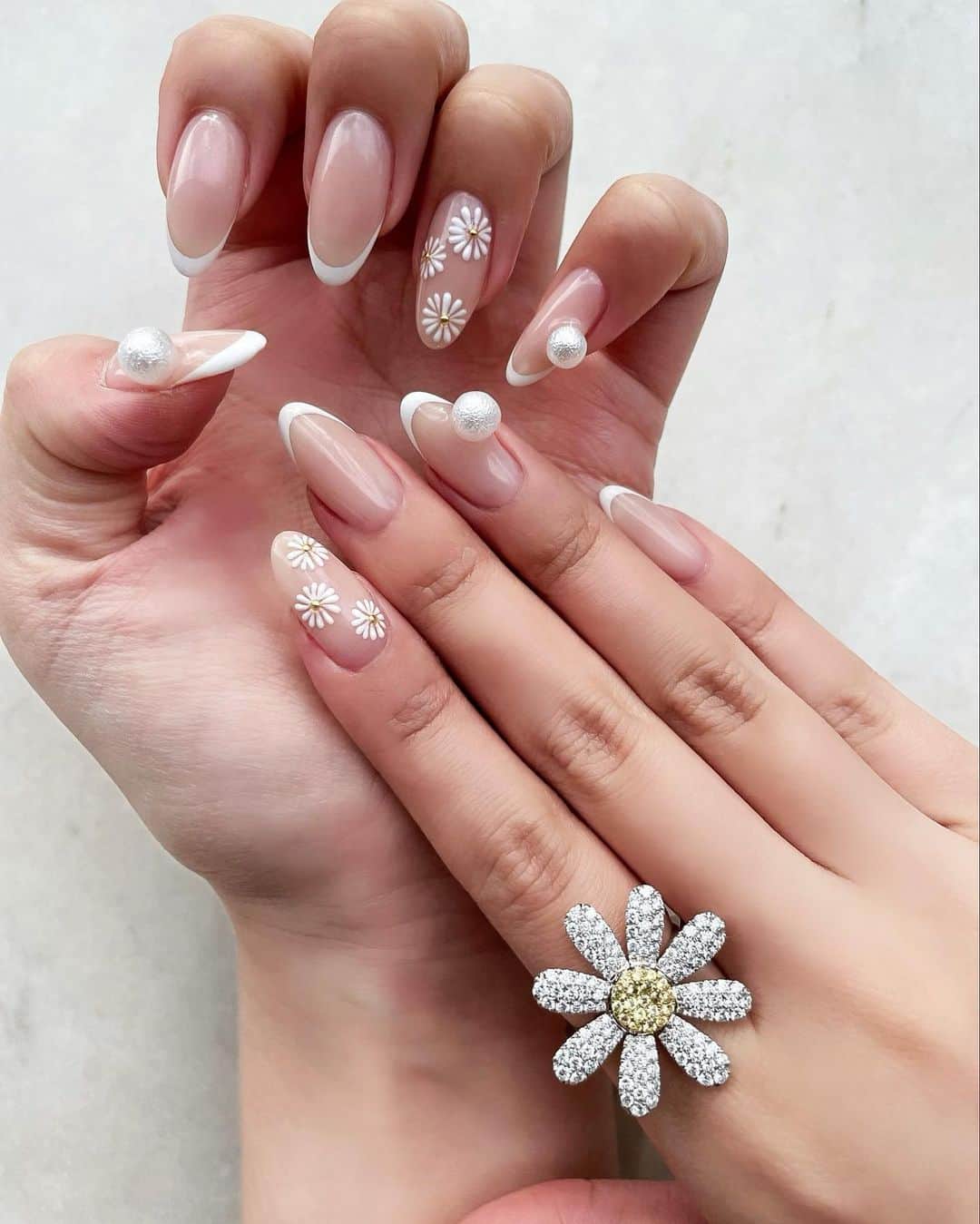 のインスタグラム：「𝑁𝑒𝑤 𝑛𝑎𝑖𝑙𓂃💅 ⁡ マーガレットのトップスとリングに合わせて‥ マーガレットネイルに🌼 ⁡ 花びらは少しぷっくりさせて 真ん中にはスタッズをON。 ⁡ マーガレットの指以外は 白フレンチとコットンパールで纏めました🦢✨ ⁡ 今回のネイルもとっってもお気に入り❤︎ ⁡ thank you... @10momoe18」