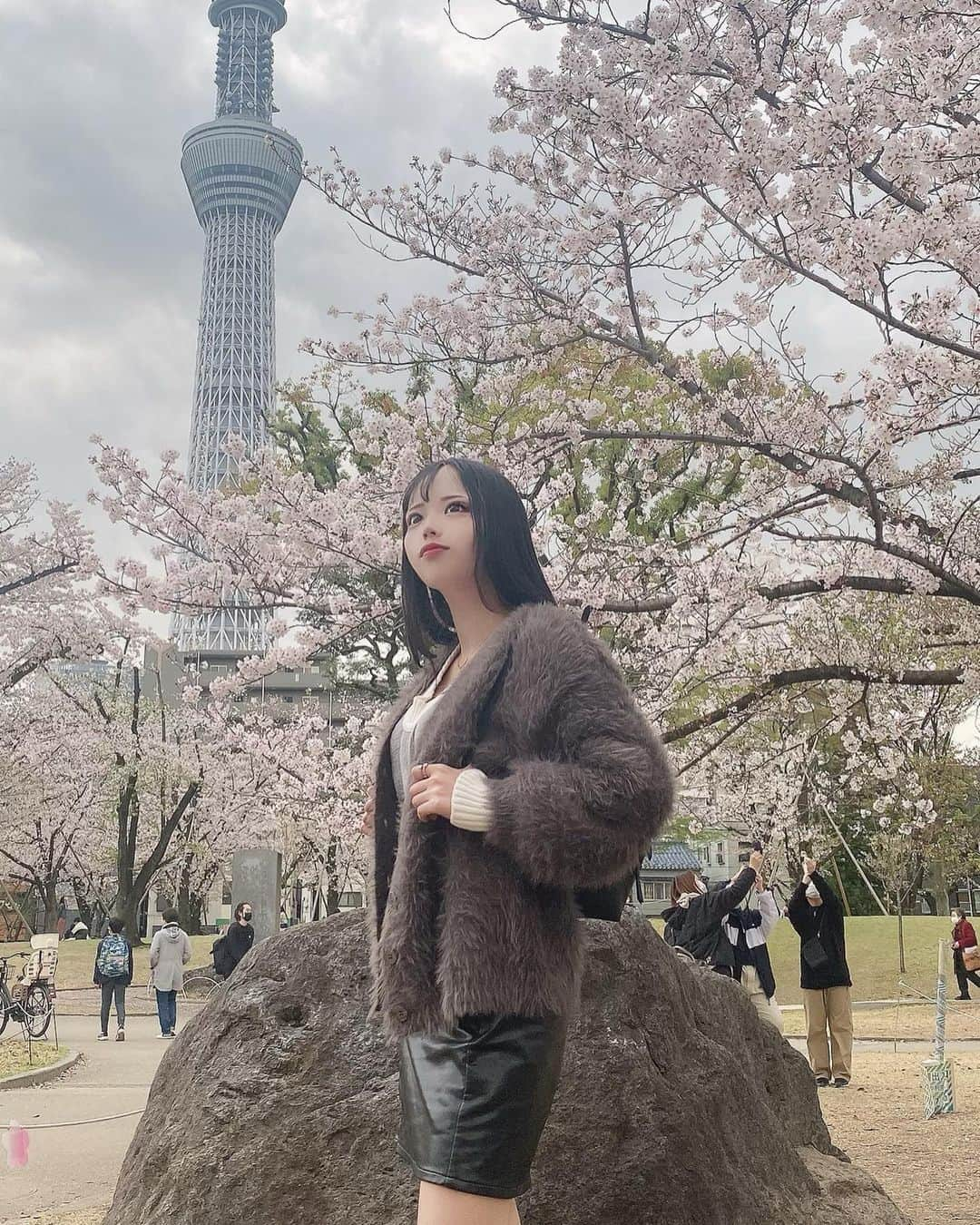 なつみのインスタグラム：「桜とスカイツリーを背に📸 そろそろ葉桜になり始めたね🍃 次は八重桜を見に行こうかな🌸 ハルジオンやチューリップ、薔薇、 その他にも見に行きたいお花が目白押し🌷´-  #ライブ配信#ライバー#八重歯#宅建士#宅建#宅地建物取引士#不動産営業#イギリス留学#バセドウ病#吃音症#過敏性腸症候群#🧢なつみ👻🍊#ファッション誌モデル#着物モデル#隅田公園#お花見#お花大好き#한국어공부#gravesdisease#stuttering」