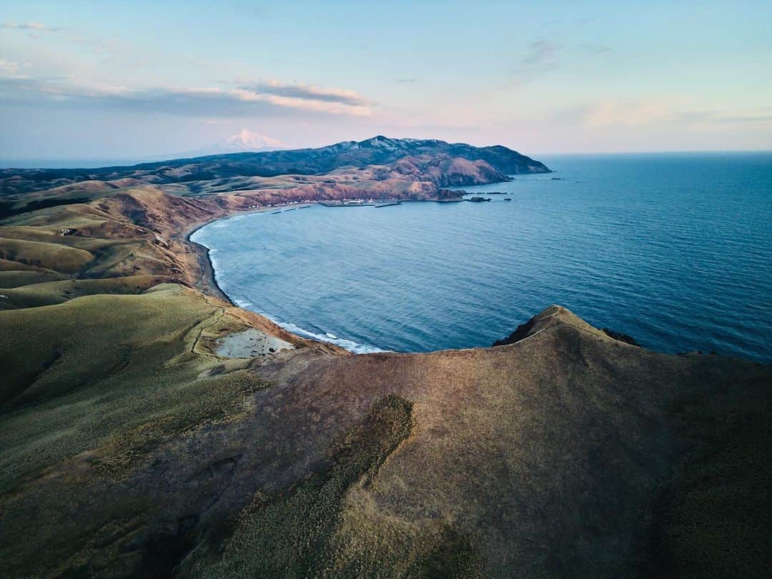 柏倉陽介のインスタグラム：「久しぶりに風が落ち着いた。手前にあるのはゴロタ岬、奥に見えるのが利尻岳。つくづく完璧な世界だ。 #礼文島」