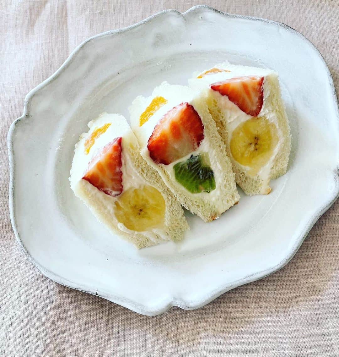 若山曜子のインスタグラム：「🍌🥝フルーツサンドレシピ🍓🍊  岡山に少し帰っていましたが、なんなのっ⁉️ていうくらいいつも晴天なのです…さすが晴れの国を名乗るだけある。（ストーリーズが桜だらけですみません。。）桜を満喫しました。  満開の桜の下、実家の母のお花見に作ったのはローストビーフ　（#おいしいルール　に載せてます） デザートには老若男女嫌いな人のいないフルーツサンドがやっぱり食べやすくてよいですね。  ☆ コツはクリームをしっかり硬めに立てること。いつもより甘めにすること。（ケーキみたいに食パン自体が甘くないので、、）  ☆マスカルポーネ を入れるとしっかりするしコクも出ます。かわりにサワークリームを混ぜるのも爽やかで美味しいですよ。  【材料】8カット分 サンドイッチ用食パン４枚、 イチゴ２個、 バナナ１／２本 キウイ１／２個 オレンジ（小）１／２個  マスカルポーネチーズ６０ｇ、ハチミツ小さじ１、 生クリーム１００ｍｌ グラニュー糖大さじ１ 【作り方】 1 クリームを作る。ボールにマスカルポーネチーズとハチミツを入れ、ゴムベラで練る。別のボールに生クリームを入れ、グラニュー糖を加えて八分立てにし、マスカルポーネと混ぜ合わせ、ピンと角が立つまでしっかりと混ぜる。 2 用意したバナナとキウイは半分に、オレンジは４等分に切っておく。食パン１枚にマスカルポーネクリームをたっぷりと塗りフルーツを乗せる。 （この写真では、、真ん中にイチゴを丸ごと１個、左上にバナナ4分の1本分、右下にキウイ4分の1個分、右上と左下にそれぞれオレンジを8分の1ずつ。） 3フルーツの隙間を埋めるようにクリームを塗り、食パンをサンドし上から手で軽く押さえてラップで全体を包む。もう１組も同様に作る。 3 上から軽くバットなどでおもしをし、１時間以上冷蔵庫に入れる。パン切り包丁で耳を切り、対角線で三角に切る。  ※レシピの転載などの二次使用はお断りしています。」