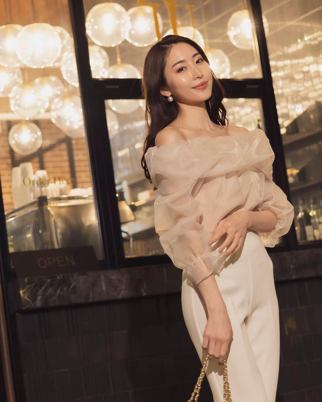 のインスタグラム：「𝑵𝒊𝒈𝒉𝒕 𝑶𝒖𝒕 𝒊𝒏 𝑻𝑶𝑲𝒀𝑶  "柔らかなワントーンで嬉々とした表現へ"  #オフショルダーオーガンジーブラウス <Beige, Black>  ふんわりと身体を包み込むエアリーな春のブラウス。  柔らかなオーガンジーでソフトな輪郭を縁取りつつも、大胆なデコルテ見せに女性らしい色香が漂います。  #ハイライズスリムフレアパンツ <White, Black>  装飾を削ぎ落としたシンプルな面持ちで、シルエットの良さが際立つ一本。  裾に向かって広がることで、膝下を長く見せ、美脚が叶う優れもの。  ＿＿＿＿＿＿＿＿＿＿＿ ✔︎ @ambient_styling #AMBIENT #ambient_official #ambientstyle #アンビエント #お呼ばれコーデ #ブラウス #デート服 #女子会コーデ #きれいめコーデ #パンツコーデ」