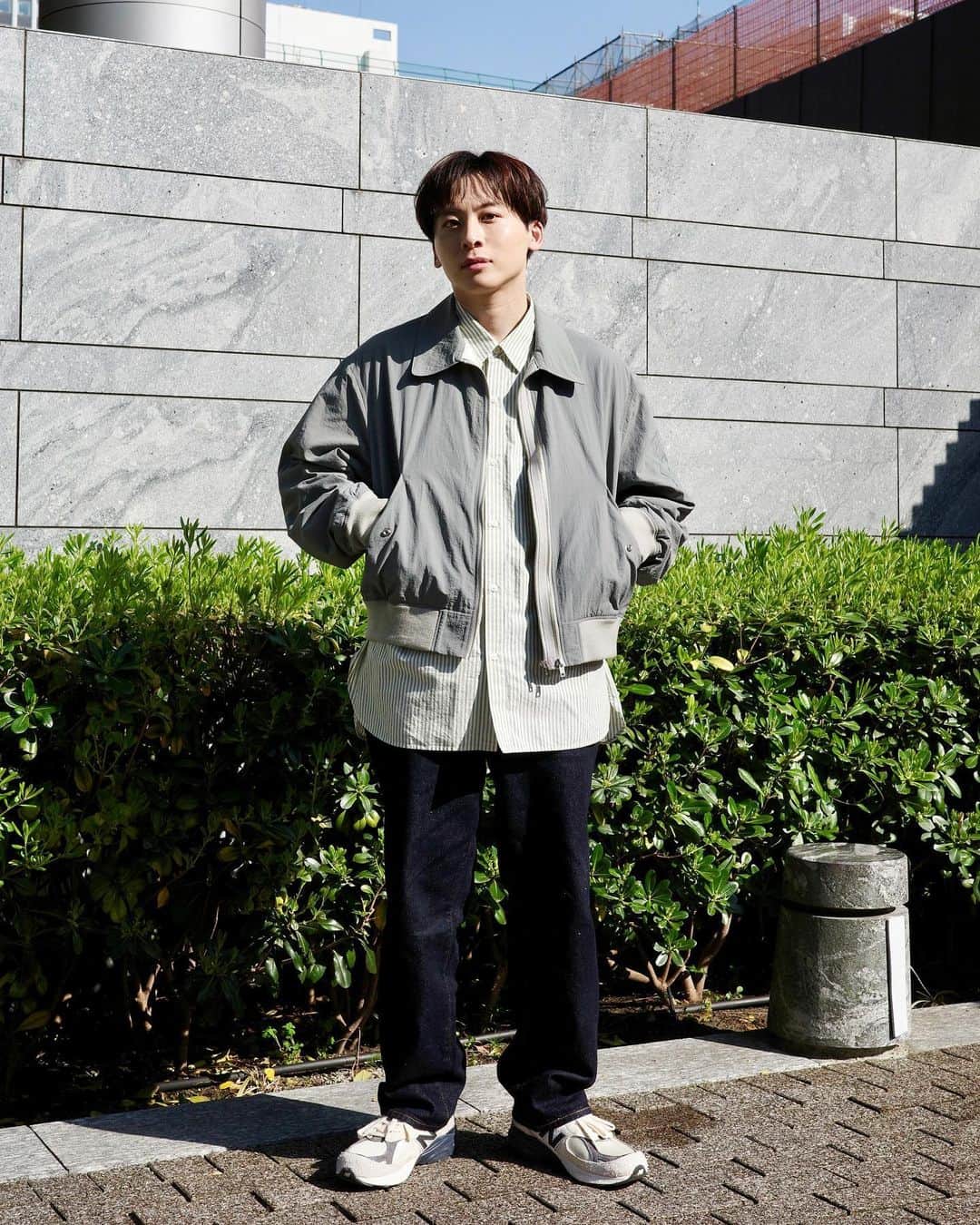 工藤大輝のインスタグラム：「私服。  温かくなってきたので案の定淡い色味を着たくなってきました。そして日差しが眩しくて眉間に皺が寄っていますが全く怒ってません。かなりウキウキです。  @ensou_official のフライトジャケット。ensou.はかなり好きなブランドでこのジャケットも無骨な配色でありつつ形は着丈が短め。そして2ジッパー。上まで閉めながら下を開けたりしてアクセントが付けられるのがポイント。 大阪 @cedarwoodgallery で購入。  シャツは数シーズン前の @cristaseya です。サイズはXLですが、XL入れてるお店がとても少ないので見つけたらラッキーだと思ってます。渋いストライプ配色に加えて何度か洗ったので生地感も渋くなってきました。  パンツは @biotop_official & @levis_japan のコラボ。STAY LOOSEの名の通り作りは割と緩め。90s感はあるけどテーパードしっかり入ってるのでSilver Tabよりはキレイめにもなる感じです。あと生地にヘンプが混じっててネップ感がしっかりあるのも面白い。Thank you @adametropehomme  靴は珍しくスニーカーを。エメレオンドレのテディが仕掛けた @newbalance の配色が好きで去年購入してた一足。形は990v3で配色名はMoonbeamだそうで、確かに月っぽい。白でもアイボリーでも無い曖昧な色が意外と合わせやすくて。しかし所々スエードなので雨の日は絶対履きたくない。降るなよー。  #ensou #cristaseya #biotop #levisforbiotop #newbalance990」