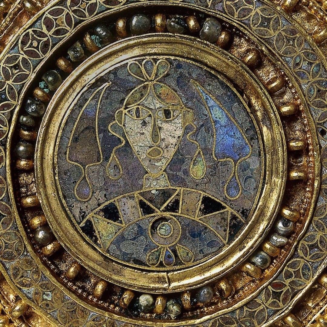 大英博物館のインスタグラム：「Got that Monday morning feeling? 😯  Made between the late 7th and early 9th centuries, this Lombardic gold brooch shows an enamelled female bust wearing a brooch with three drop-shaped pendants, with stylised cypress trees either side of her head ✨  The Lombards were a Germanic people who invaded Italy through western Hungary in AD 568. During the two centuries of Lombardic rule, Italy experienced a cultural revival in which urban life flourished.   Lombardic women adopted the Mediterranean fashion for single disc brooches, replacing their traditional Germanic dress.  🏛 See this beautiful brooch on display in Room 41 – The Sir Paul and Lady Ruddock Gallery of Sutton Hoo and Europe, AD 300–1100.  🔎 Gold disc brooch, with a central roundel of cloisonné enamel. Canosa di Puglia, Italy, AD 600s – early AD 800s.   #BritishMuseum #Gold #Jewellery」