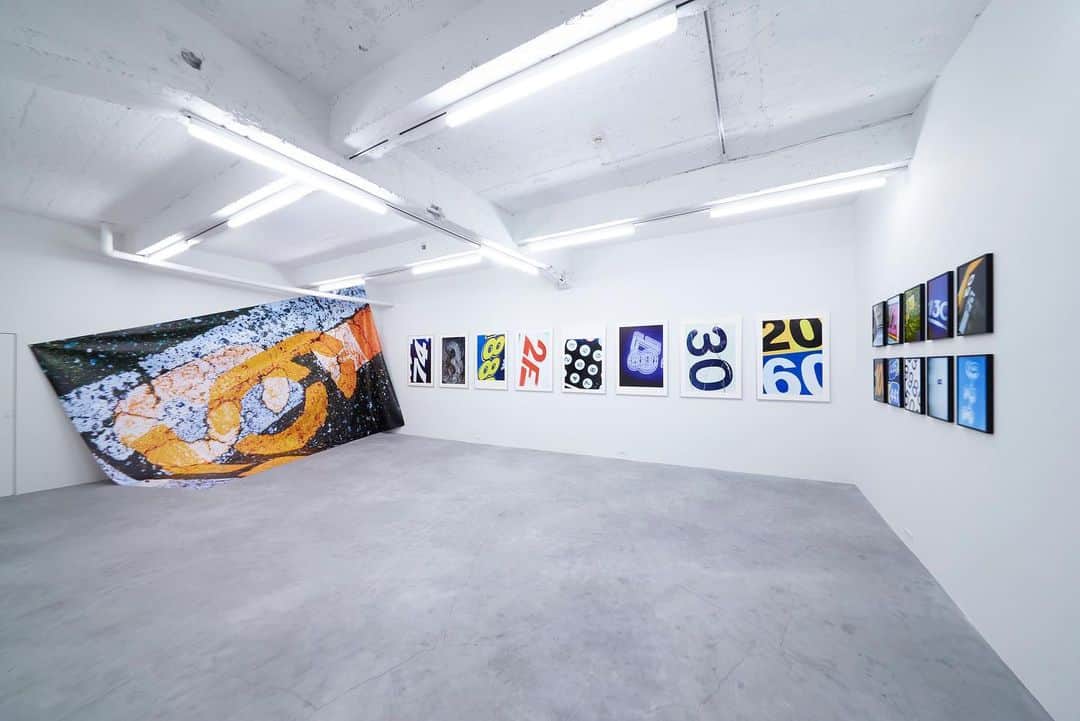 小見山峻のインスタグラム：「. 来週末より新作の個展がスタートします。 以前より興味を持ち撮り続けてきたモチーフである「数字」の写真になります。  14日18〜21時で久しぶりにレセプションも行いますので、ご都合あいましたらぜひお立ち寄りください。 . . .  小見山峻 個展 9876543210 [ Nine to Zero ]  2023年4月14日（金）〜5月14日（日） opening reception 4月14日 18:00〜21:00 月火休廊  この度 SOM GALLERY は、小見山峻 による新作個展「9876543210 ( Nine to Zero )」を、日本橋馬喰横山にて開催します。  小見山は神奈川県横浜市出身の写真家、アーティスト。 「現実の出来事に対する視点を記録する」という写真の本質を突き詰め、コンピュータによる合成加工などに頼ることなく、グラフィカルな世界を表現、建築している。  小見山は、ストリートを映し出すことを出発点とし、これまで自身の周囲におけるリアリティを独自の視点で切り取ってきた小見山は、かつての東松照明や植田正治、森山大道らがそこに存在する空気やダイナミズムを切り取ったように、一貫して自らを取り巻く世界に存在する在るが儘の真実やその痕跡を映し出すことを重視している。  本展は、「数字」という、全世界で共通の意味を持ち、人間だけが認識しえるモチーフを素材にすることで、数字が持つ寓意的な意味を探る。 人類は古くから数字を用いて、他者との関わりを築いてきた。現代においても同じく、数字は言葉が通じない状況でも意思を伝えるための強力な記号であり、概念である。 一方で、それら記号は、時に人々を縛り付けるという逆説的な意味を持ち合わせている。資本主義社会においても、記号として用いられることで価値を有していた数字が、ラベルとして意味づけされることで、本来持ち合わせている価値が埋没することもある  現在の写真表現は、複製可能性や印刷等の特性に目が向けられ、写真が持つ本質的価値や表現が希薄化しているのではないか。 そのような写真の存在を数字になぞらえて、写真が持つ本質的価値の再定義を試みる。  小見山は、自身が将来を通じて表現するモチーフの一つとして、「数字」という記号を見つけ出した。 街に存在する数多の記号（数字）を写真という行為で切り取り、内包する意味を昇華させ、新たな生命を宿す。この行為こそ、小見山の考える、現在の正統な写真表現と言えるだろう。  皆様のご来場を、心よりお待ち申し上げます。  SOM GALLERY URL：https://www.somgallery.com/ Mail：somgallery05@gmail.com」