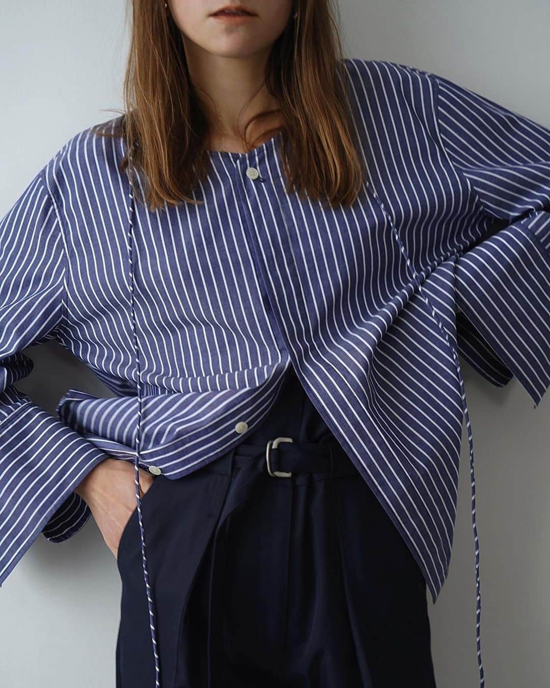 clane_officialのインスタグラム：「■NEW ARRIVAL 4月7日(金)発売アイテムをご紹介。  デコルテがボートネックに広く開いた女性らしいシャツトップス。衿ぐりに施された紐を首に巻いたりホルター風に結んでアレンジできます。  袖口は広めに設定したボリュームのあるシルエットですが、身頃は程よいサイズ感でイン・アウトどちらも着やすいです。前開きデザインなので、羽織りとしても着用できます。  ✔︎ DECOLLETE LINE BLOUSE ¥24,200 カラー：ホワイト、ストライプ  #CLANE」