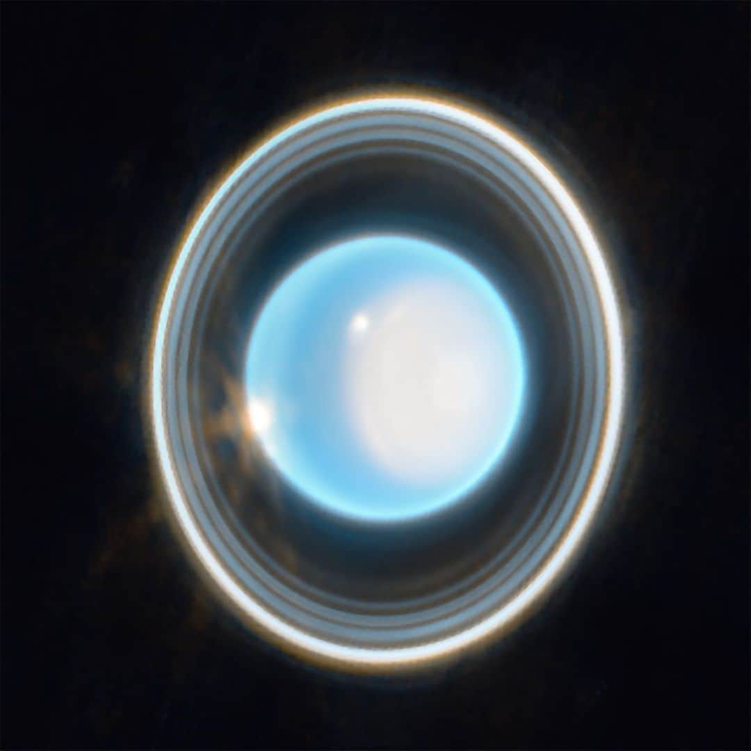 NASAのインスタグラム：「Uranus. (Go ahead, get it out of your system. We tried.)⁣ ⁣ The @NASAWebb telescope highlights 11 of the seventh planet’s 13 rings. Only Voyager 2 and Keck (with adaptive optics) have imaged the planet's faintest rings before, and never as clearly as Webb.⁣ ⁣ In the first image, check out the polar cap (bright white area) on the right side. Webb reveals a subtle enhanced brightening at its center. This polar cap appears in the direct sunlight of summer and vanishes in the fall. Webb's data will help us to understand this mystery.⁣ ⁣ Take a look at Uranus’s moons in the second image. Most of its 27 moons are too small and faint, but the 6 brightest ones are visible. (The other bright objects are background galaxies.)⁣ ⁣ This was only a 12-minute exposure image! It's just the tip of the ice(planet)berg for what Webb will uncover. Read more at the link in @NASAWebb’s bio.⁣ ⁣ Image descriptions:⁣ ⁣ 1. The planet Uranus on a black background. The planet appears light blue with a large, white patch on the right side. On the edge of that patch at the upper left is a bright white spot. Another white spot is located on the left side of the planet at the 9 o’clock position. Around the planet is a system of nested rings. The outermost ring is the brightest while the innermost ring is the faintest. Unlike Saturn’s horizontal rings, the rings of Uranus are vertical and so they appear to surround the planet.⁣ ⁣ 2. The planet Uranus is on a black background just left of center. It is colored light blue and displays a large, white patch on the right side as well as two bright spots and a surrounding system of nested rings oriented vertically. Just below the planet at the 7-o’clock position is a faint blue point labeled Puck. Brighter blue points at 8 o’clock, 5 o’clock, and 3 o’clock are labeled Ariel, Miranda, and Umbriel, respectively. Farther from the planet, two additional blue points at 7 o’clock and 5 o’clock are labeled Titania and Oberon. Faint orange smudges are scattered in the background.⁣ ⁣ Credit: NASA, ESA, CSA, STScI, with image processing by Joseph DePasquale (STScI)⁣ ⁣ #JWST #JamesWebbSpaceTelescope #Uranus #SolarSystem #NASA #space」