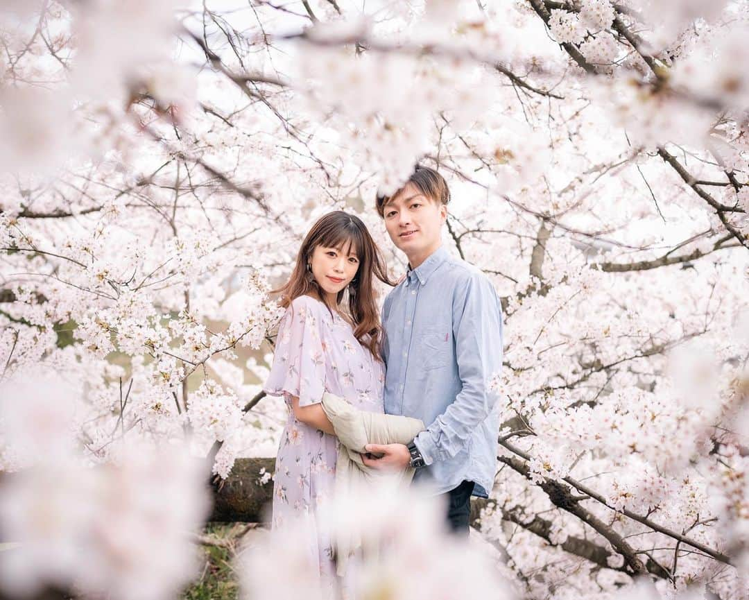 小林舞香のインスタグラム：「We took pictures at Kajo-Park where the cherry blossoms were in full bloom. It was cloudy, but the atmosphere was very nice surrounded by white sky and cherry blossoms in full bloom.  We'd like to leave a lot of pictures that I can show to my son. He'll think "My father and mother used to be like this!”   I'm seven months pregnant now. I want to tell him that this is spring when you were in my body🤰  Regarding the photo taken at @unitecafe the other day, my brother-in-law and photographer @hikaru.studio9 took it. Actually, the photo of the live painting from a year ago was also him. He always takes great pictures, so I'm grateful that a great photographer is my brother-in-law...✨🙇‍♀️✨ . . Photo by @hikaru.studio9  . #japan_of_insta #lovers_nippon #art_of_japan_ #cherryblossom #team_jp_ #japantravelgallery #photo_shorttrip #photo_jpn #ptk_japan⠀ #sakura  #山形 #霞城公園  #霞城公園の桜  #桜並木 #桜スポット #桜巡り #桜 #夫婦」