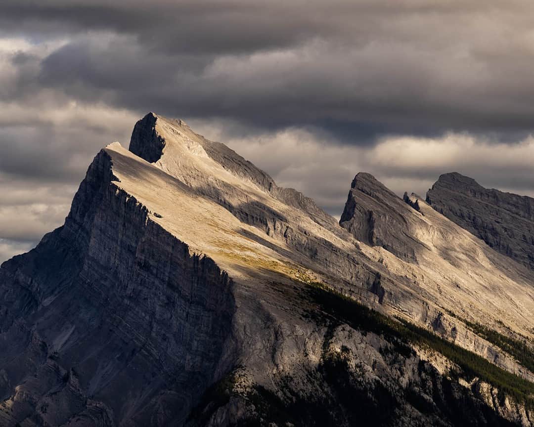 National Geographic Travelさんのインスタグラム写真 - (National Geographic TravelInstagram)「Photo by @stephen_matera | Sunlight breaks through heavy clouds to illuminate the summit of Mount Rundle in Banff, Canada. Mount Rundle rises more than 9,600 feet (2,900 meters) above the town and is an iconic feature of the skyline around Banff, one of the most popular destinations for tourists in Canada. Follow me @stephen_matera for more images like this from Canada and around the world. #CanadianRockies #Banff #NationalPark」4月8日 1時00分 - natgeotravel