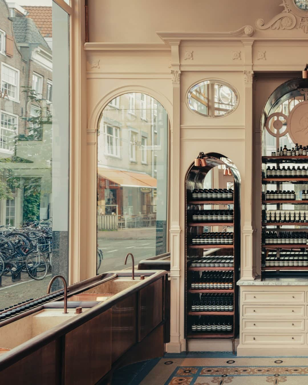 イソップさんのインスタグラム写真 - (イソップInstagram)「Aesop Utrechtsestraat: sensual curves revitalise a historic sweet shop.   A collaboration with Studio Valentin Loellmann, this Amsterdam store inhabits a seventeenth-century corner building that speaks a geometric language of ovals and lines. Arched joinery wraps the room, recalling the locale’s past life as a sweet shop. In dialogue with these structures, Loellman created a series of handmade timber and copper pieces that lend the store a warm, nuanced personality.   Photography by @romainlaprade.」4月8日 18時00分 - aesopskincare