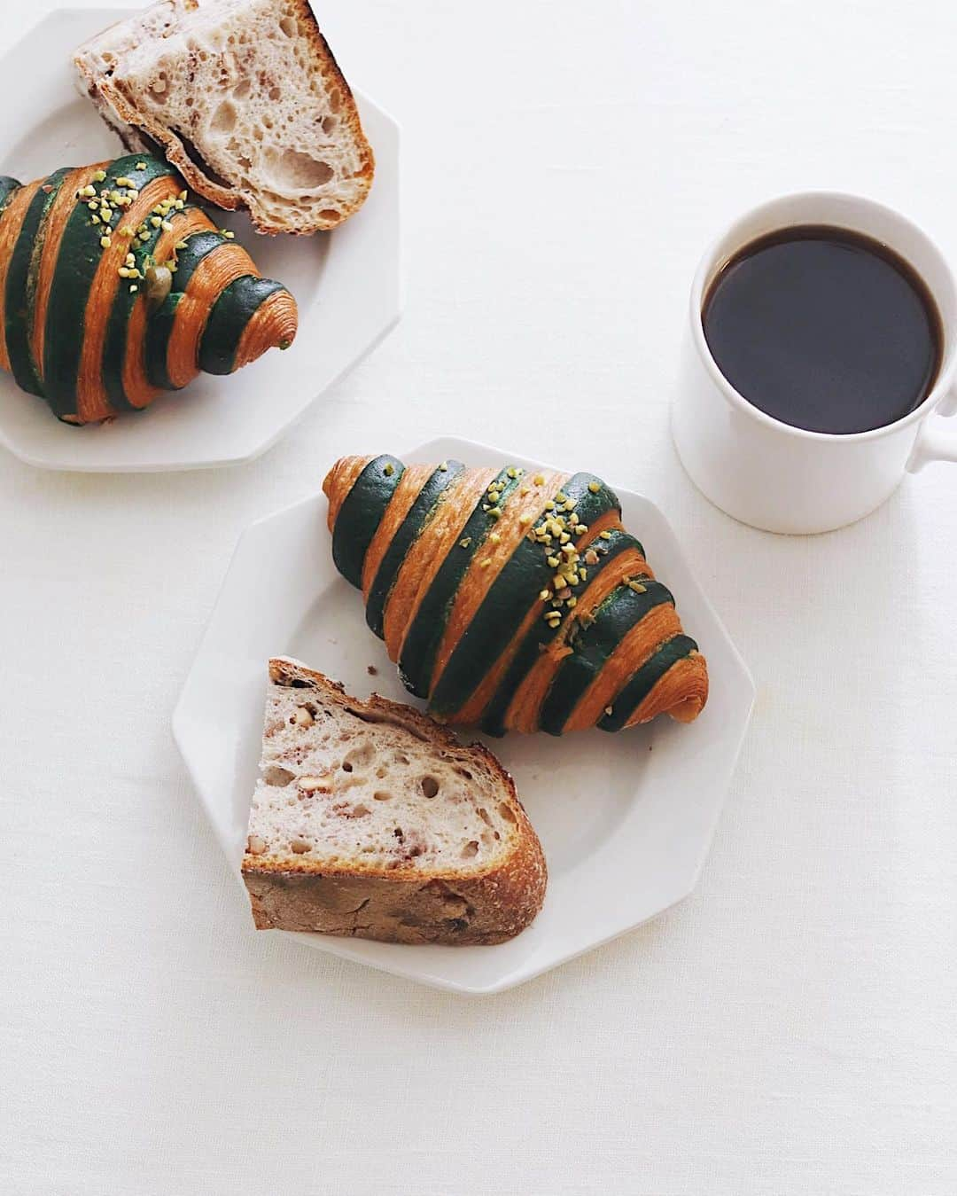 樋口正樹のインスタグラム：「Today's breakfast 🥐 . 朝ご飯にご近所のパンを２種、 ル・リュー・ユニークさんの ピスタチオ・クロワッサンと クルミパン。そしてコーヒー☕️ . . . #ルリューユニーク #クロワッサン #クルミパン #ピスタチオクロワッサン #武蔵小山 #武蔵小山パン屋 #パン屋巡り #パン好き #ナッツ好き #LeLieuUnique #lelieuuniquebakery #croissant #painauxnoix」