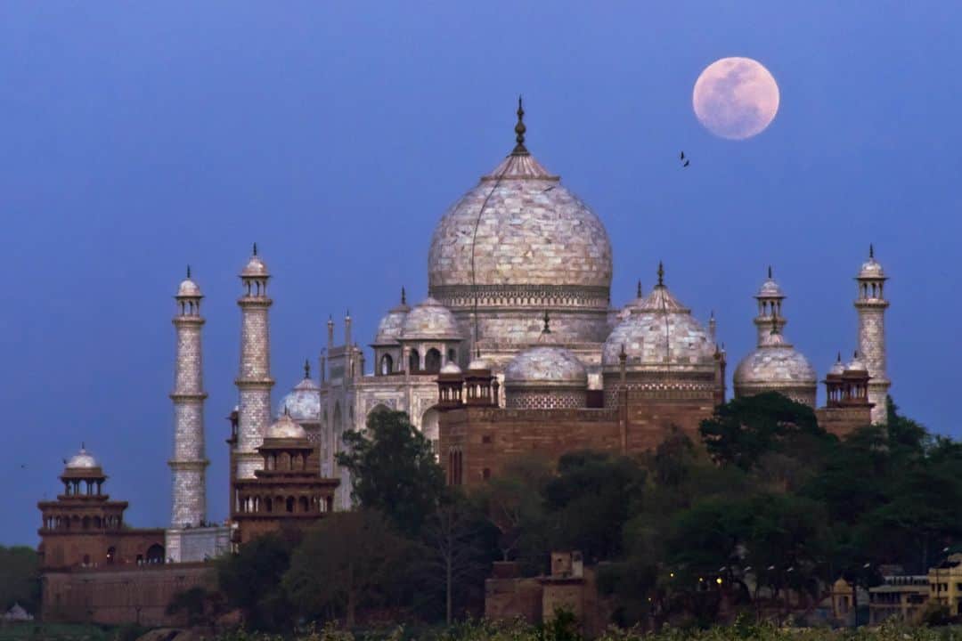 National Geographic Travelさんのインスタグラム写真 - (National Geographic TravelInstagram)「Photos by @babaktafreshi | A full moon rises above the Taj Mahal at dusk. This World Heritage site of white marble is considered a monument to eternal love. Mughal Emperor Shah Jahan commissioned the palace after the death of his beloved Persian wife Mumtaz Mahal, and it was constructed in Agra, India, between 1632 and 1648. On the five nights each month before, during, and after the full moon, you can visit the Taj Mahal at night, when the marbles shine brightly in the moonlight.」5月4日 23時00分 - natgeotravel