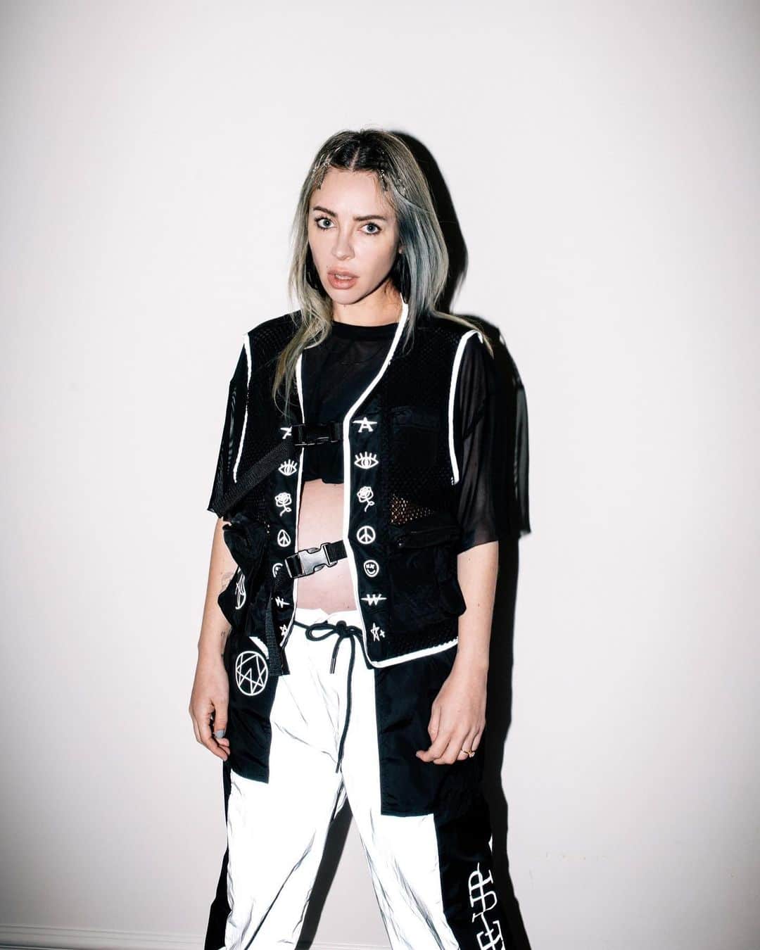アリソン・ワンダーランドのインスタグラム：「So excited to present the Alison Wonderland x iHr limited edition capsule collection. On sale tomorrow 11am PST. Swipe to the end to see the entire collection. Reflective vest, reflective joggers, black light leg wraps, holographic hydration pack, earrings (swipe to the very end for an extra surprise)」