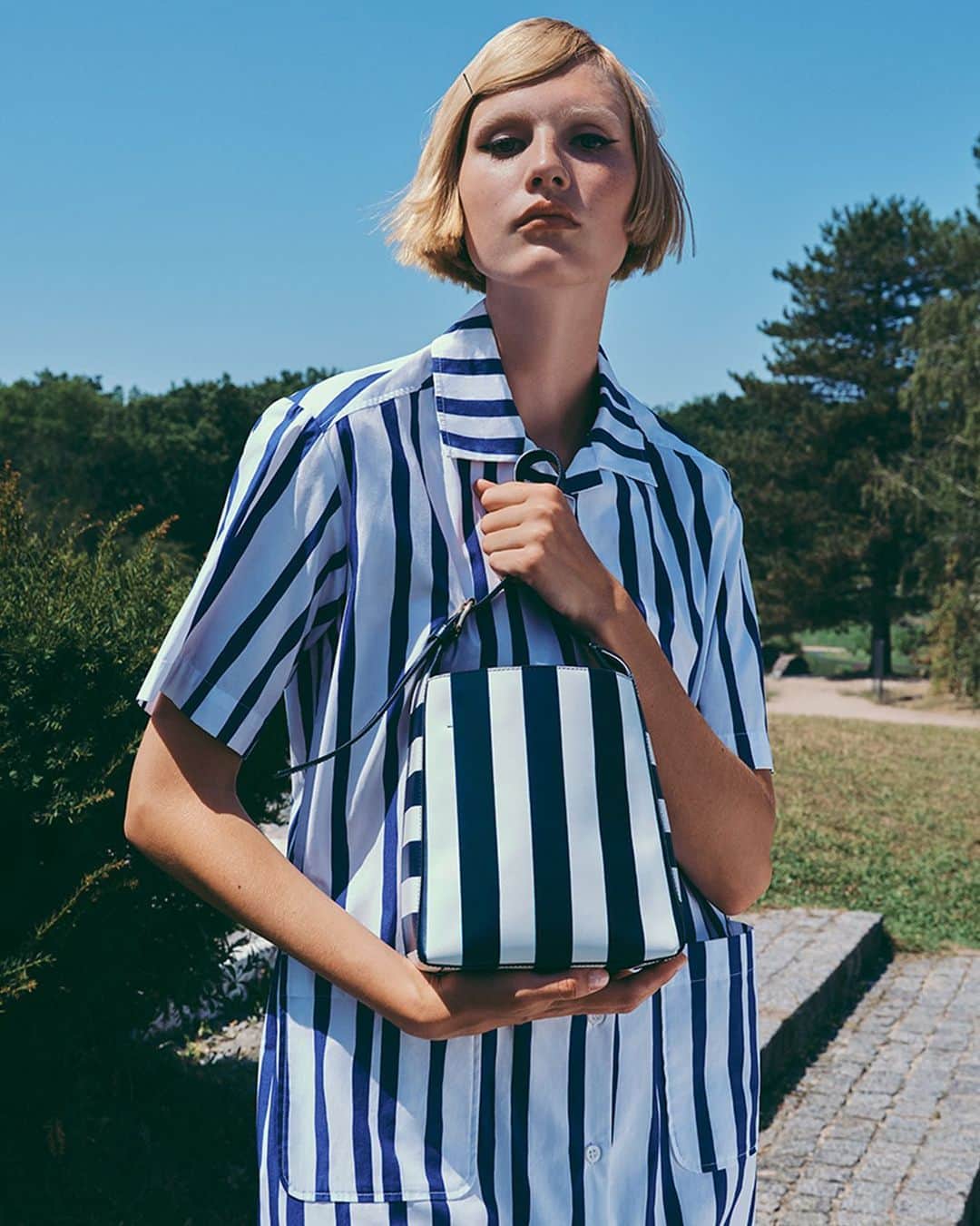 アーペーセーのインスタグラム：「S/S23 stripes.   @elisa_nijman wears the Virginie small bag in striped dark navy and Rosita dress.   Creative direction & Styling: @suzannekoller Photography: @samrocksamrock  #APCParis」
