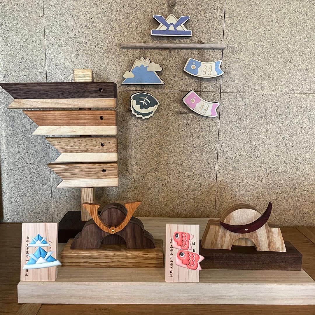 のインスタグラム：「こどもの日🎏 双子ちゃんの初節句。 兜飾りを父母が購入してくれるとのことで、豪華絢爛な五月人形は我が家にはスペースの都合により飾れず、棚におけるコンパクトなサイズの木製の兜と鯉のぼりをお願いしました。職人さんが手作業で檜で作ってくださっていて可愛い。鯉のぼりの緋鯉はオプションで1匹増やしました。 名札もついています。ゆうピーはザ！兜って感じの前立て。はるピーは伊達政宗のような三日月🌙型にしてみました。  #こどもの日 #五月人形 #鯉のぼり #兜 #ゆうピーはるピー #初節句」