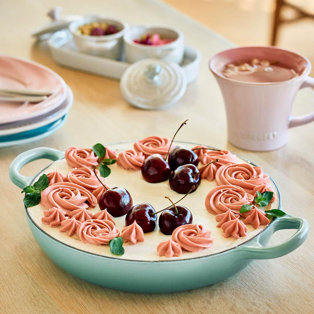 Le Creuset Japon　ル・クルーゼ ジャポンさんのインスタグラム写真 - (Le Creuset Japon　ル・クルーゼ ジャポンInstagram)「【ル・クルーゼ 公式レシピ】お花のホワイトショコラケーキ ガトーショコラベースのホワイトショコラケーキ。白とピンクのコンビネーションが可愛らしく、お祝いやプレゼントにも最適な華やかなケーキです。すぐに手に入る材料で簡単に焼け、お花のクリームも市販の生クリームパックに付いている絞り口で作ることができます。  材料【1台分/シグニチャー ビュッフェ・キャセロール 22cm】 ホワイトチョコレート　　　　　 200g バター (有塩)　　　　　　　　　 150g   卵　　　　　　　　　　　　　　　4個 薄力粉　　　　　　　　　　　　　50g ブランデー　　　　　　　　　　　適量 グラニュー糖　　　　　　　　　　50g   (A) 生クリーム　　　　　　　　　　　200ml グラニュー糖　　　　　　　　　　10g   (B) 生クリーム　　　　　　　　　　　100ml イチゴチョコレート　　　　　　　75g ※ルビーチョコでも可   〈トッピング〉 アメリカンチェリーなど旬の果物　適量 アラザン　　　　　　　　　　　　適量 ミント　　　　　　　　　　　　　適量  作り方 〈下準備〉 ・ 卵は卵黄と卵白に分け、卵白は冷蔵庫で冷やしておく。 ・ 薄力粉は振るっておく。 ・ オーブンは180℃に予熱しておく。 ・ クッキングシートをキャセロールの円周よりも5cmほど大きい円形に切り、中央に向かって5cmほどの切れ目を螺旋状（らせんじょう）に入れておく。鍋に油(分量外)を塗りクッキングシートを貼り付ける。  1. ホワイトチョコレートと有塩バターをボールに入れて湯煎する。溶けたら湯煎から外し、卵黄を加えよく混ぜる。  2. 1.に薄力粉を入れ、ダマができないように混ぜる。  3. 別のボールに卵白を入れ、泡立て器で泡立て、グラニュー糖を３回に分けて加える。ボールを傾けても動かないくらいのしっかりとしたメレンゲを作る。  4. 2.にメレンゲの1/4を入れよく混ぜる。残りのメレンゲを３回に分けてさっくりと混ぜ、鍋に流し入れる。  5. 180℃に予熱したオーブンで20分焼き、170℃でさらに20分焼く。竹串を刺し何もついてこなければ焼き上がり。鍋を傾けて生地をそっと取り出し、粗熱をとる。  6. 粗熱が取れたら、クッキングシートを取り外し、鍋に戻し入れる。鍋からはみ出ている生地部分があれば切り落とし、表面にブランデーを塗る。  7. ボールに(A)を入れ、ツノが立たない程度まで泡立て、ケーキの表面を覆うように塗る。  8. 別のボールに(B)を入れ、湯煎をして溶かす。溶けたら氷水を当てながら泡立てる。  9. 8.を絞り袋に入れ、ケーキに渦を描くようにお花状に絞る。  10. ミントの葉やアメリカンチェリーなどの旬のフルーツ、アラザンを飾る。  11. 1時間ほど冷蔵庫で落ち着かせる。  #ルクルーゼ #lecreuset #ルクルーゼのある暮らし #ルクルーゼごはん #テーブルウェア #キッチンウェア #キッチングラム #ルクルーゼのある生活 #ルクルーゼのある食卓 #食卓 #食卓グラム #キッチンツール  #ホワイトショコラ #手作りケーキ #デザートづくり #簡単デザート #簡単デザートレシピ #簡単おやつレシピ #手作りデザート #簡単レシピ #手作りスイーツ #手作りおやつ #手作りお菓子」5月7日 13時00分 - lecreusetjapon