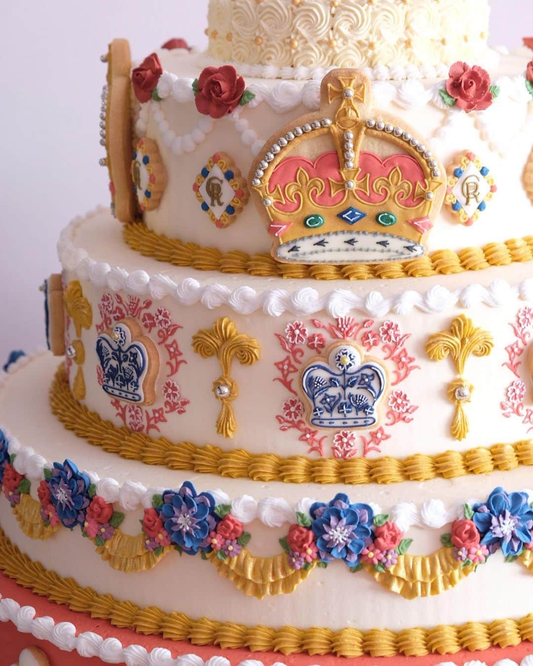 KUNIKAのインスタグラム：「For the coronation cake and biscuits design, I included the kings Charles Ⅲ emblem CR, the crown, and kings favorite flowers, delphiniums, peonies and roses. 🎂🌹  戴冠式ケーキのデザインは、チャールズ3世国王陛下の紋章や、王冠モチーフ、お気に入りの花であるデルフィニウムや薔薇やピオニーなどを沢山使用しました。  2枚目の動画のように、ぐるっと一周、どこから見ても同じデザインになっています🎂」