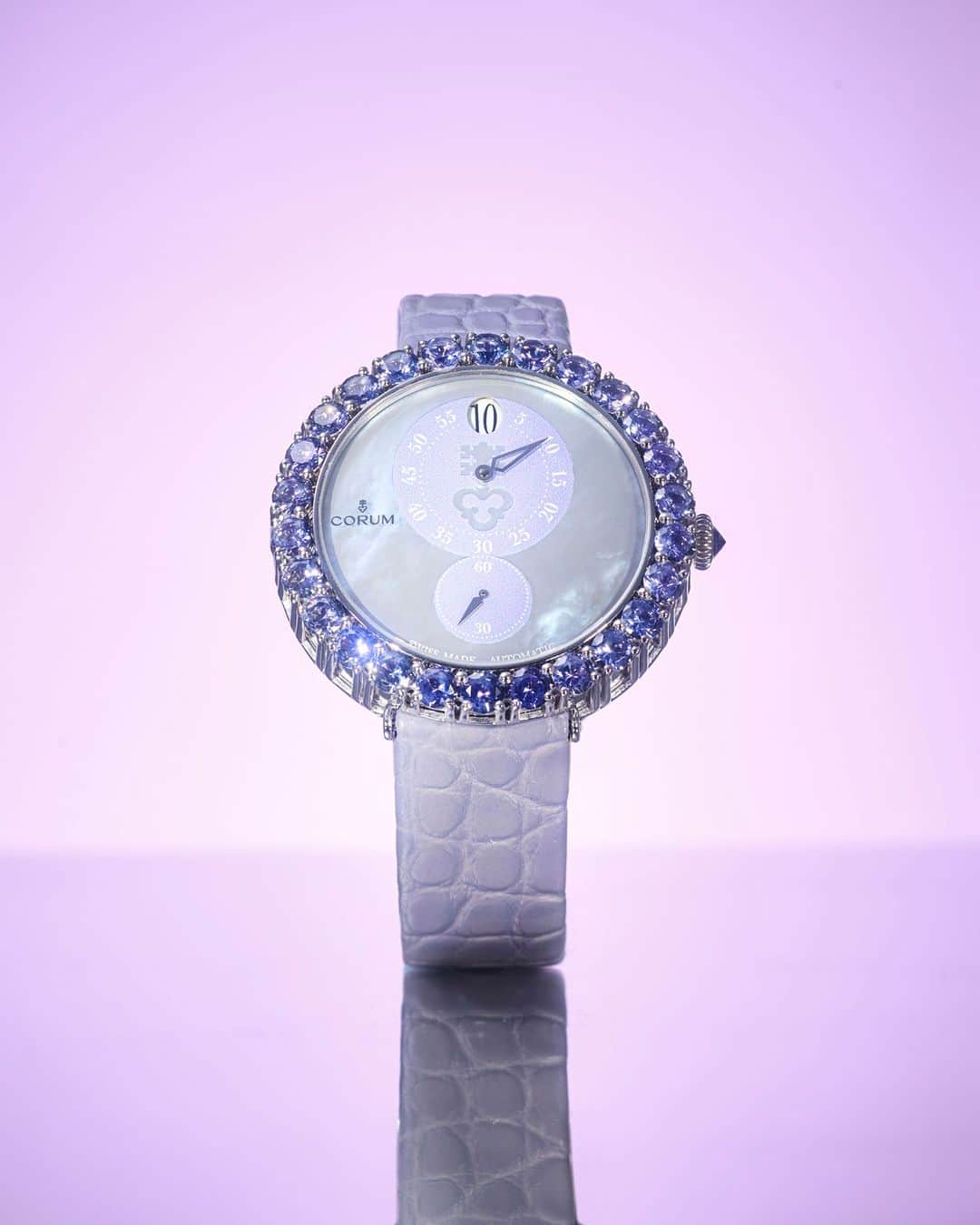 コルムのインスタグラム：「計27石の宝石を配したラグジュアリーなベゼル・リューズ。品格と理性を感じさせるタンザナイトを、優雅にあしらっています。  品番： Z254/03644 価格： ¥5,500,000(税込)  ___ #高級腕時計 #CORUM #コルム #コルム時計 #コルムウォッチ #腕時計  #ヘリテージコレクション #luxurywatch #watchwithlove #watchaddict」