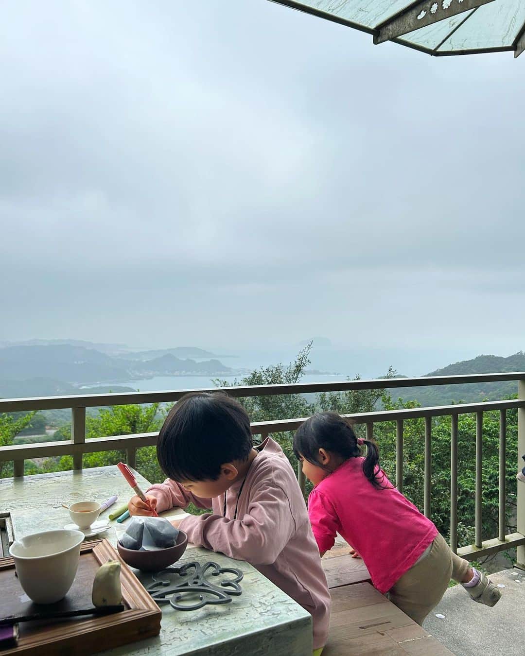 砂賀美希さんのインスタグラム写真 - (砂賀美希Instagram)「台湾旅行は今回4回目。 なかなか行けずにいた九份エリアへ。 千と千尋の神隠しのモデルと言われている有名な場所の近く、 賑やかな観光エリアから少し脇道に入った 海を一望できる水心月茶坊でゆっくり台湾のお茶をいただきました。  この日は曇り空でガスっていたけれど ドラゴンの通り道？ってくらいに天空に抜ける景色で たくさん深呼吸。  いただくお茶も淹れ方から丁寧で上質 甘味から深み渋みに変化していく過程も楽しめました。 あまりお茶を飲まない子供達も「甘い！」と喜んでました🍵  印象的だったのが お茶で漬けた茶梅、が昔おばあちゃん家でよく出てきたお茶請けの味がして 一気にあの頃のあの家にいるあの時のわたしに戻されたこと… すごいよね、記憶って。 日本から持ち込んだ食文化なのかな、もしかしたら。🤔📝  台北のガヤガヤした喧騒から少し離れて 家族でのんびり お絵描きしたり本を読んだり、景色を眺めてぼーっとしてみたり 何をするでないチルタイム。  子供がいなかった頃は予定も立てずに行き当たりばったりで 気に入ったところに長時間滞在することも多かったなぁ〜と 忘れてた時間の流れがここにはありました。 豊かさをどこに感じるのか、変化しますのね😌  とはいえここは静かにお茶を飲む場所。 実際は子供達をたしなめるのに手こずりましたが お茶の鮮度と景色に心癒される滞在でした。  PM1:30オープンが静かで狙い目📝 今度は1人で訪れよう🍵🤞  #台北観光 #千と千尋 #九份おすすめスポット #子連れ海外旅行 #子連れ台湾 #子連れ台北旅行 #おすすめ茶藝館 #水心月茶坊 #台北日帰り旅行 #茶梅 #今年やってみたいこと #お茶を楽しむ」5月7日 23時12分 - kimiganasu