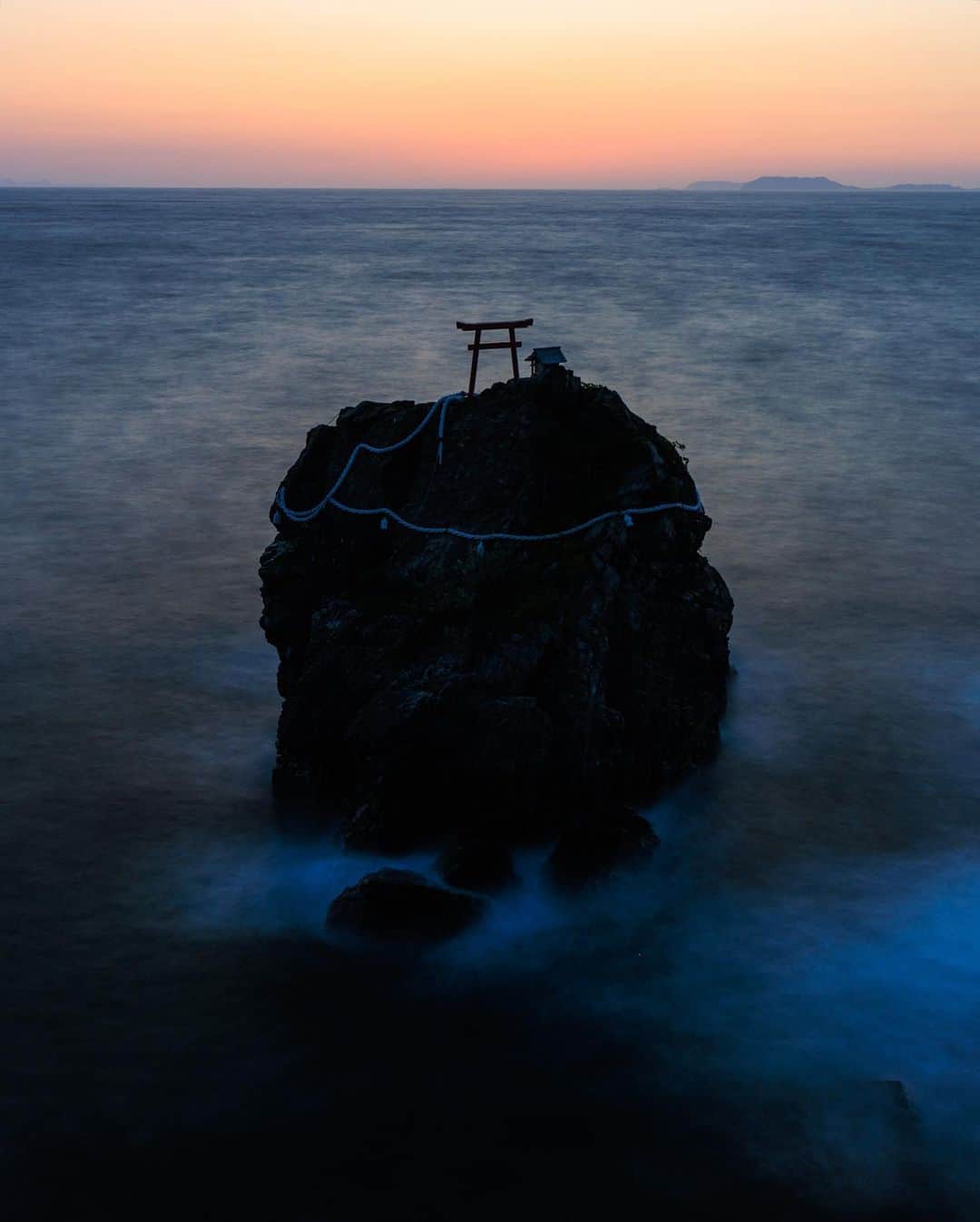 SHOCK EYEさんのインスタグラム写真 - (SHOCK EYEInstagram)「光の道がしめ縄の施された大岩の鳥居にかかる。 なんとも神々しい光景🙏✨  ここに来るのは2度目。 愛媛県大洲にある綱掛岩は僕が大好きな場所だ。  静かな波音と気まぐれな海風に沈みゆく夕陽。  日頃の疲れを忘れて無心でシャッターを下ろす。 心が洗われるよう。  ゴールデンウィークも終わり、今日からまた忙しい毎日と思うけど、 この写真を見て元気と運気をつけて、張り切っていきましょう💪✨  #綱掛岩 #愛媛県 #三島神社 #絶景」5月8日 8時58分 - shockeye_official