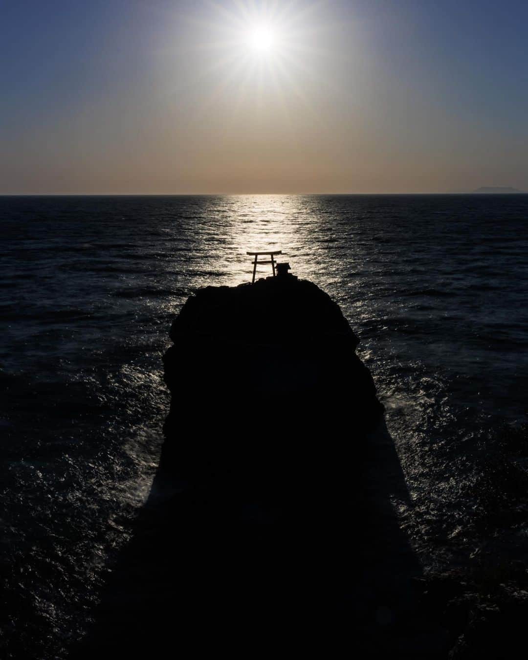SHOCK EYEさんのインスタグラム写真 - (SHOCK EYEInstagram)「光の道がしめ縄の施された大岩の鳥居にかかる。 なんとも神々しい光景🙏✨  ここに来るのは2度目。 愛媛県大洲にある綱掛岩は僕が大好きな場所だ。  静かな波音と気まぐれな海風に沈みゆく夕陽。  日頃の疲れを忘れて無心でシャッターを下ろす。 心が洗われるよう。  ゴールデンウィークも終わり、今日からまた忙しい毎日と思うけど、 この写真を見て元気と運気をつけて、張り切っていきましょう💪✨  #綱掛岩 #愛媛県 #三島神社 #絶景」5月8日 8時58分 - shockeye_official