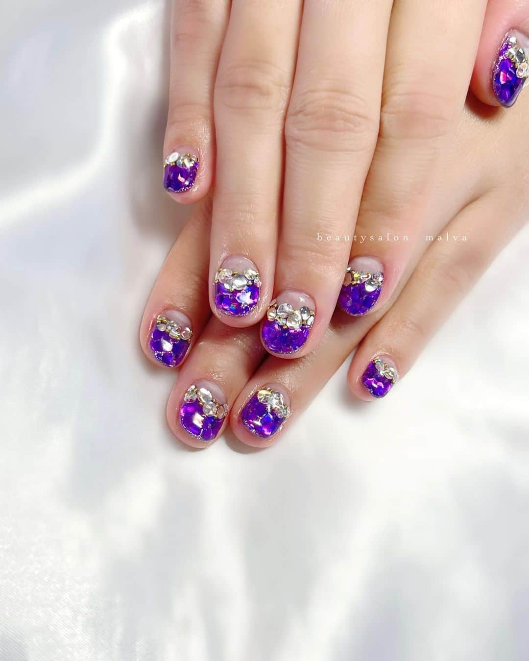 nailsalon malva（ネイルサロンマルヴァ）さんのインスタグラム写真 - (nailsalon malva（ネイルサロンマルヴァ）Instagram)「【キラキラアート002】でご予約可能✨ ⁡ パープルのホログラムが眩しいほどに ぎっしり敷き詰めた逆フレンチネイルです💅 ⁡ さかいめにのせたストーンは 爪の大きさに合わせて変えて ⁡ ロングな方も、ショートな方も似合う大きさを セレクトしてのせていきますのでお任せください☺️ ⁡ 𓂃𓂃𓂃𓂃𓂃𓂃𓂃 ⁡  𝗯𝗲𝗮𝘂𝘁𝘆𝘀𝗮𝗹𝗼𝗻  𝗺𝗮𝗹𝘃𝗮 明治神宮前駅｜原宿駅　徒歩3分 ⁡ ⁡ ⠀ ご予約・お問い合わせ ↪︎公式LINE @ malva ⁡ 　／ 　お気軽にご連絡ください♪ 　＼ ⁡ 𓂃𓂃𓂃𓂃𓂃𓂃𓂃 ⁡ ▸ ジェルネイル｜スカルプ｜ケア ▸ まつげカール｜まつげエクステ ▸ ハーブよもぎ蒸し ▸ セレクト化粧品 ⁡ ⁡ \ サロンスペース面貸し / ⁡ 原宿の竹下通りから一本はいったところ とても良い立地です✨ ⁡ 都内で場所を探している技術者さん お気軽にDMください✉︎ ⁡ 《レンタル有》 ネイルデスクチェア｜アイリストベッドワゴン｜ エステワゴン｜ リクライニング・フルフラットベッド よもぎ蒸し椅子...etc ⁡ 𓂃𓂃𓂃𓂃𓂃𓂃𓂃 ⁡ \ アシスタント・アイリストも募集中！ / ⁡ ▸リモート可オンラインの画像動画制作アシスタント ▸原宿のサロンワーク全般アシスタント ⁡ お気軽にDMください✉︎ ⁡ ⁡  #ホログラムネイル #逆フレンチネイル #ゴテゴテネイル #malva #malvaネイル #ネイル #パープルネイル #キラキラネイル  #pastelnails #原宿ネイルサロン #ネイルサロン  #表参道ネイルサロン　#明治神宮前ネイルサロン  ⁡ ⁡」4月14日 16時26分 - malva_nail