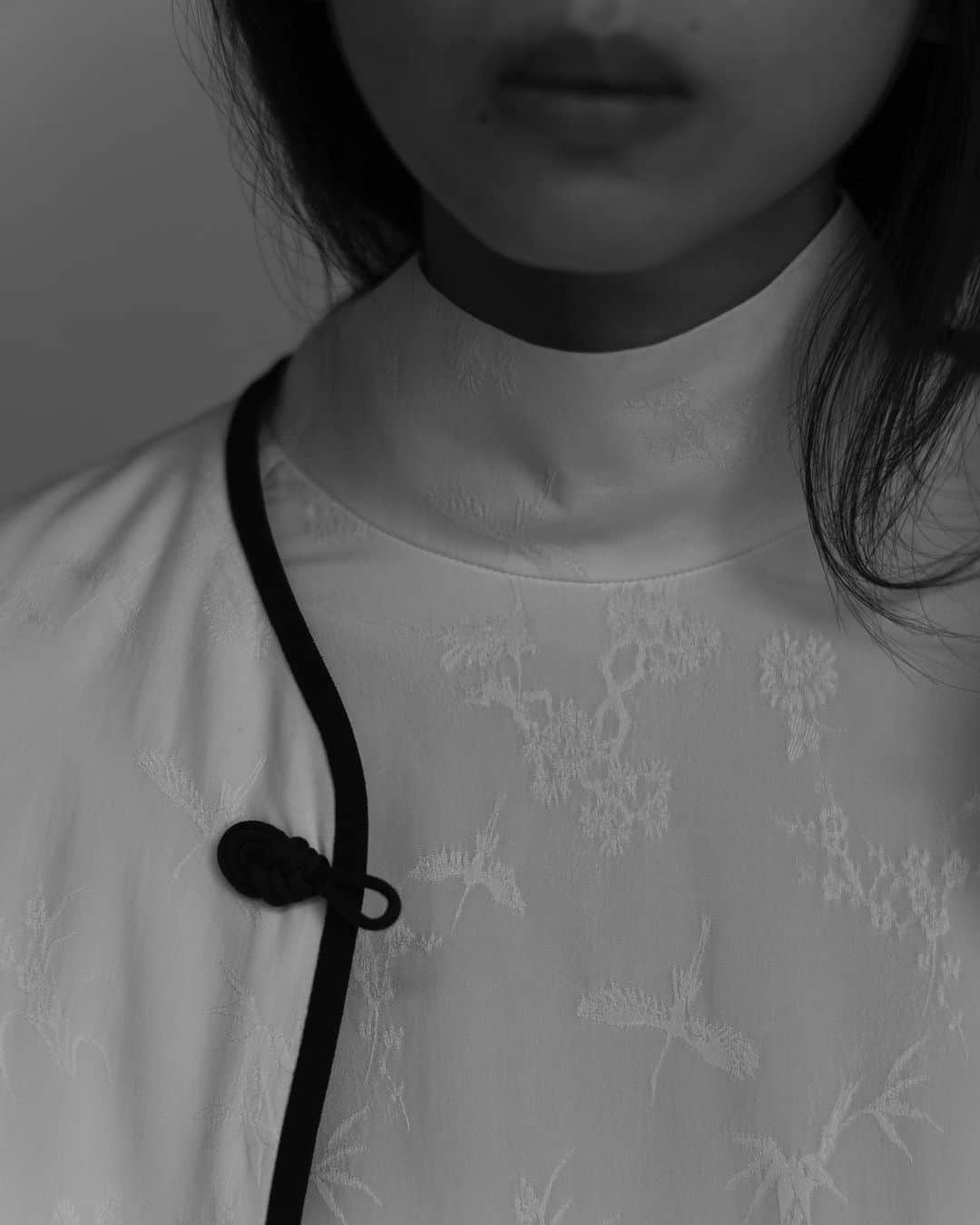 黒河内真衣子のインスタグラム：「冬を越すために越冬地と繁殖地を移動する丹頂が、まるでダンスをしているかのように優雅に飛ぶ姿を思い描きながら、ジャカードで織り上げたCrane Pattern Jacquard。 経糸にレーヨンフィラメント、緯糸にシルクを使用し、鶴の細い嘴や羽の1枚1枚の重なりに至るまで、ジャカード織で繊細な柄表現を施しています。 レーヨンとシルクの光沢差を利用して柄に組み込んでいくことで、立体的な見え方になるように織り上げ、最後に柔軟加工をすることで、しなやかでドレープ性のある素材に仕上げています。 チャイナジャケットの中綿は、シルク紡績の際に発生するわたくずを再利用し、シート状にする特許技術で作られたシルクわたを使用しています。 じわーと、優しく温かいのが特徴です。 夜になるとまだ肌寒い、花冷えの日もあります。 そんな日にそっと羽織って頂けたら嬉しいです。  #mamekurogouchi」